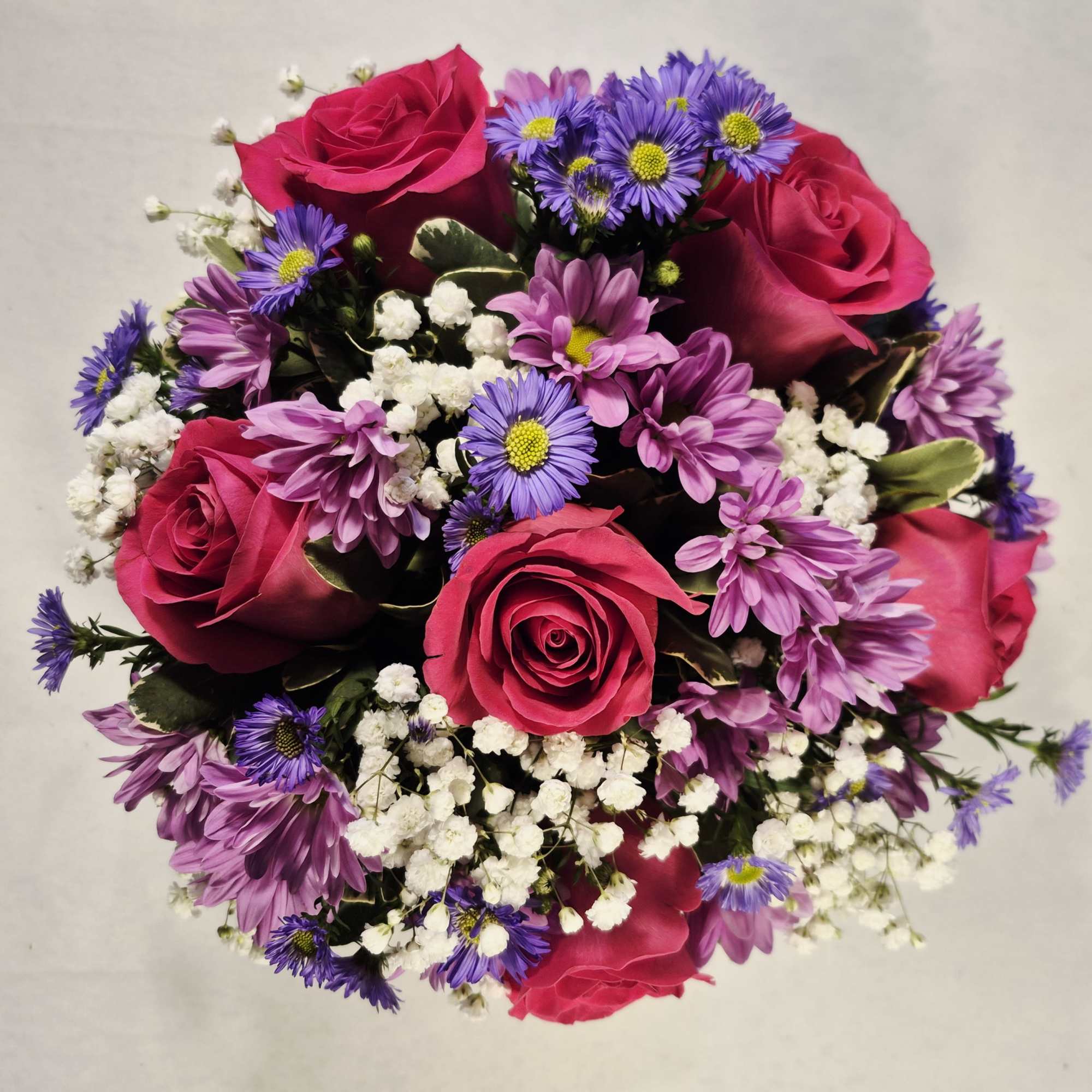 Bouquet of pink roses with purple daisies and white baby's breath