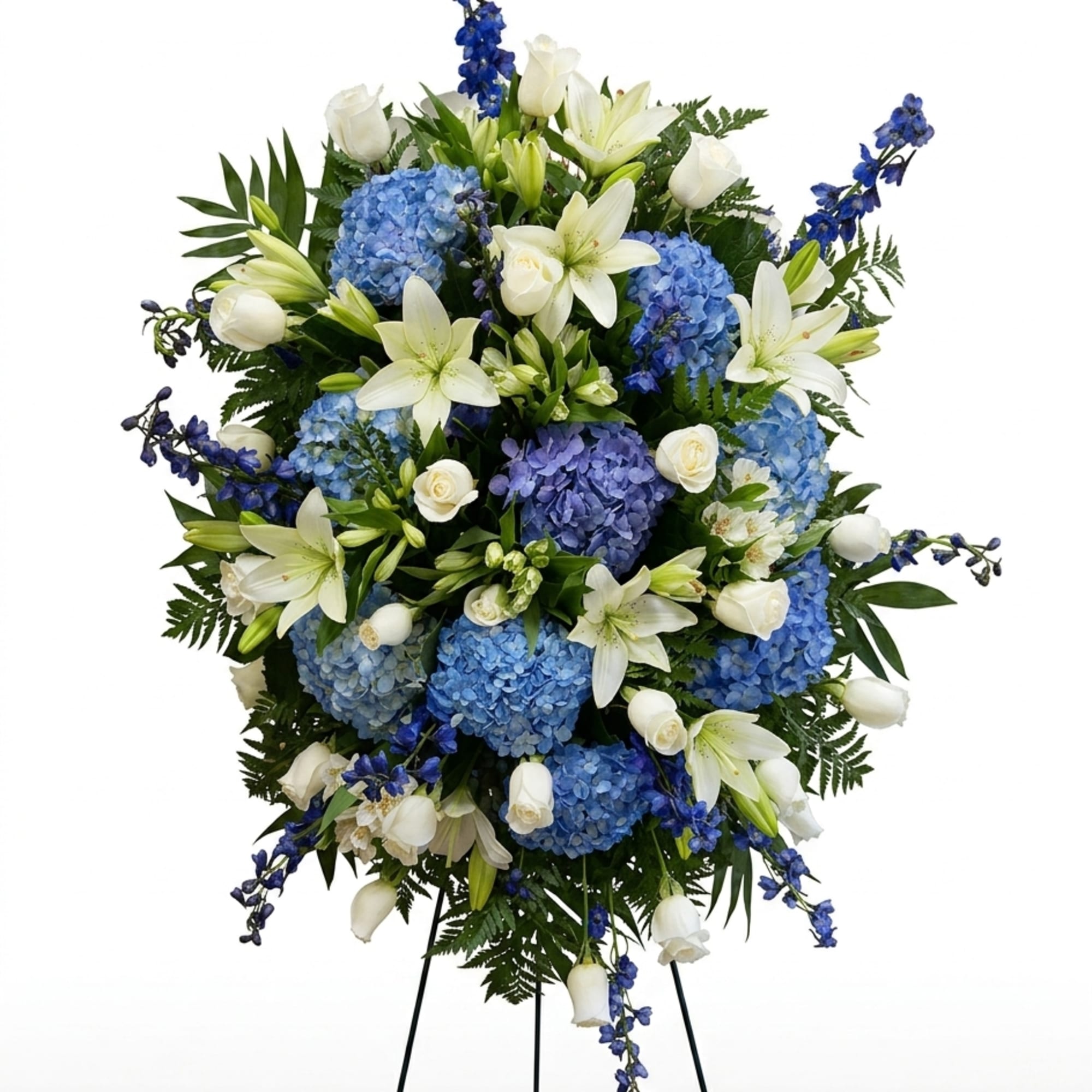 A serene display of pale blue hydrangeas and white lilies, this sympathy