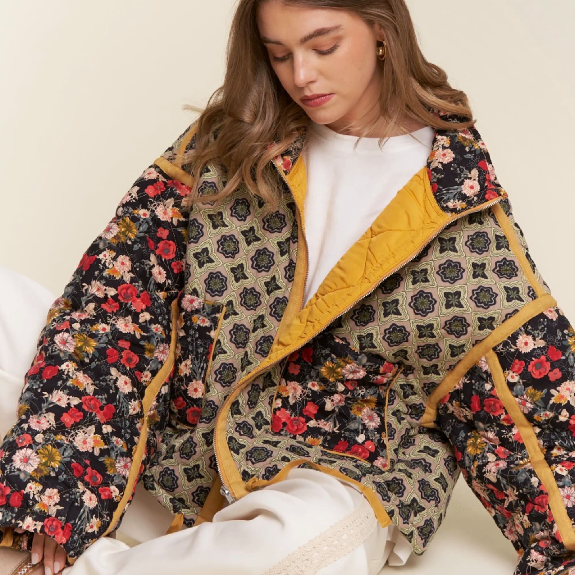 Woman wearing a floral patchwork quilted jacket over a white outfit