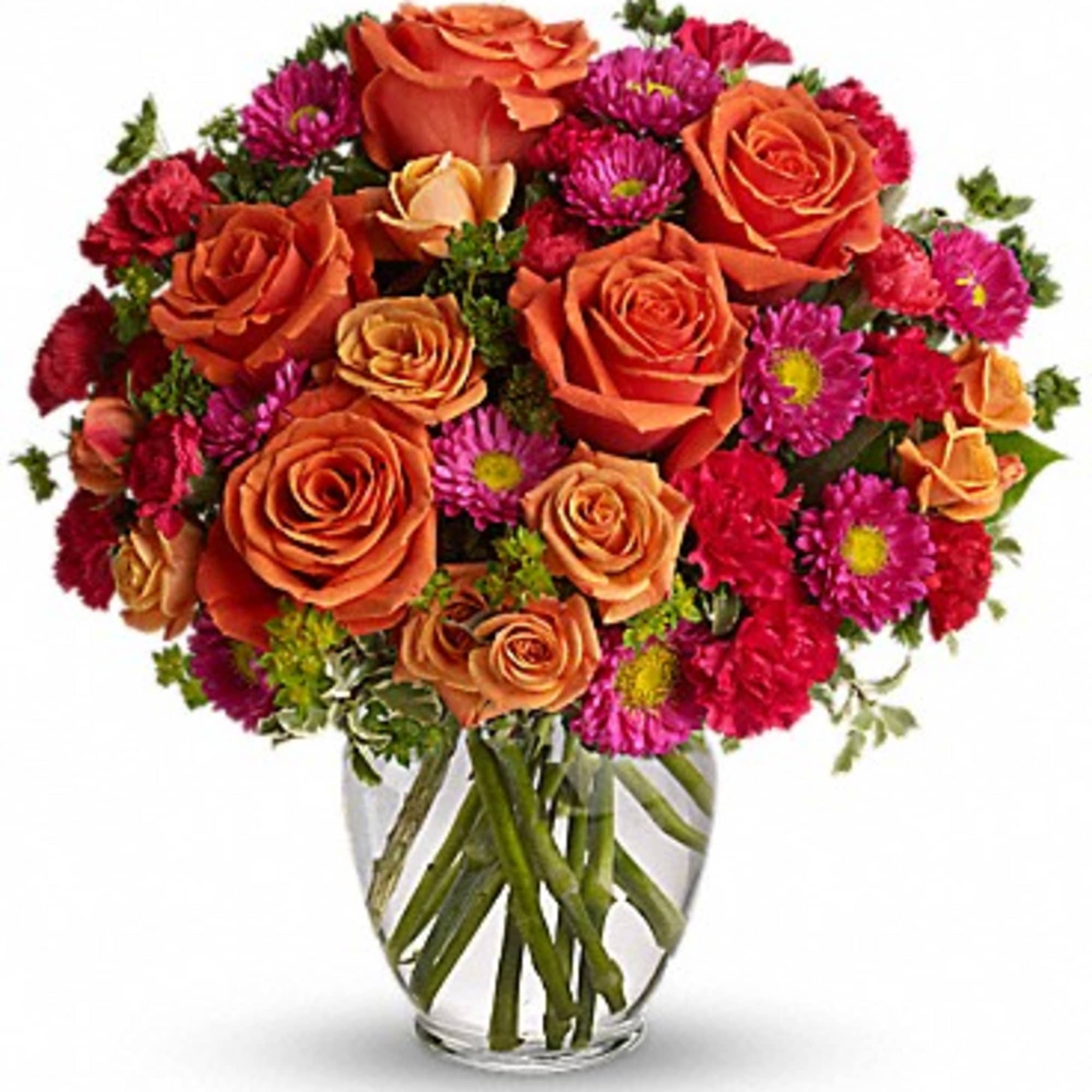 Orange roses and magenta daisies in a clear glass vase