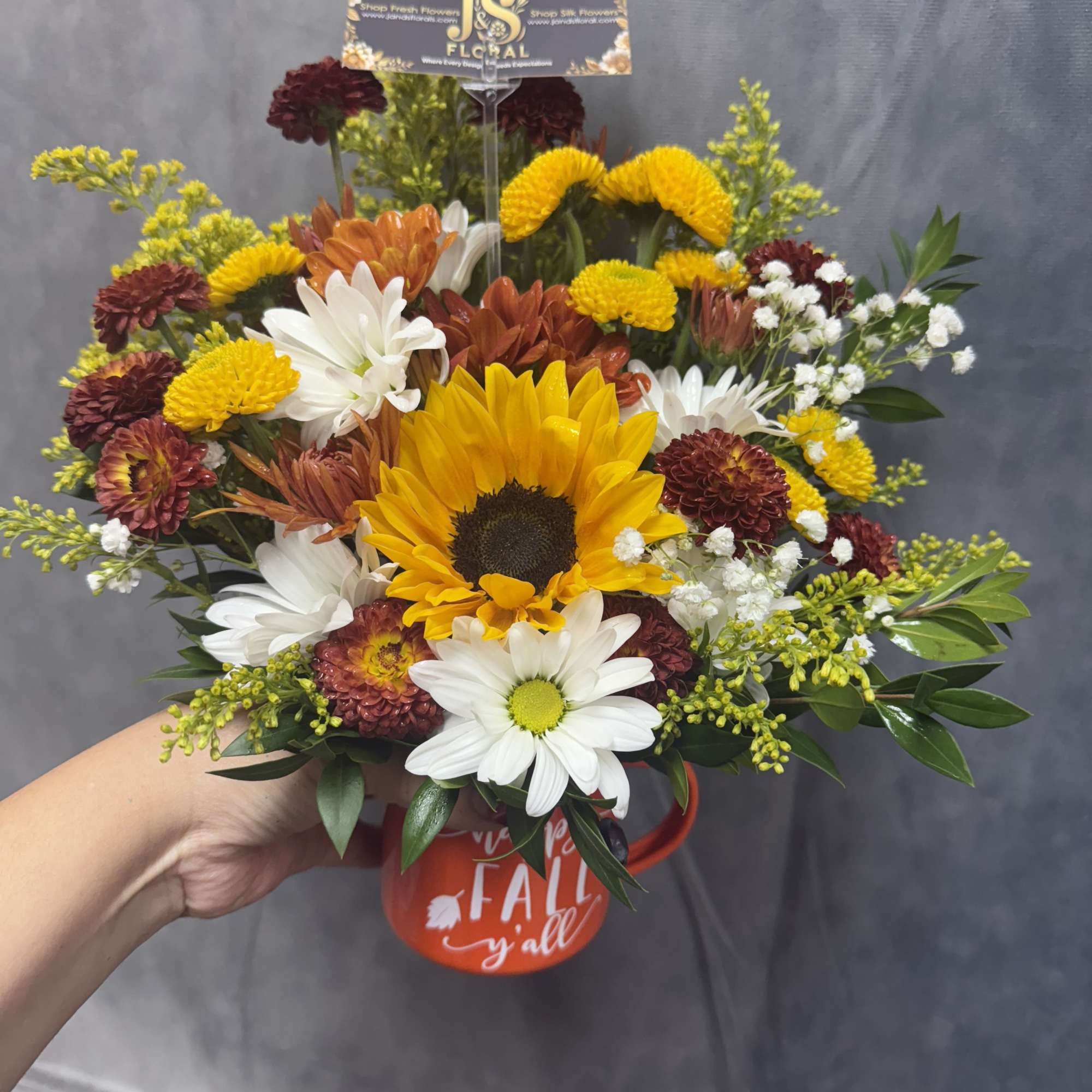 Mixed bouquet with a sunflower in a red mug