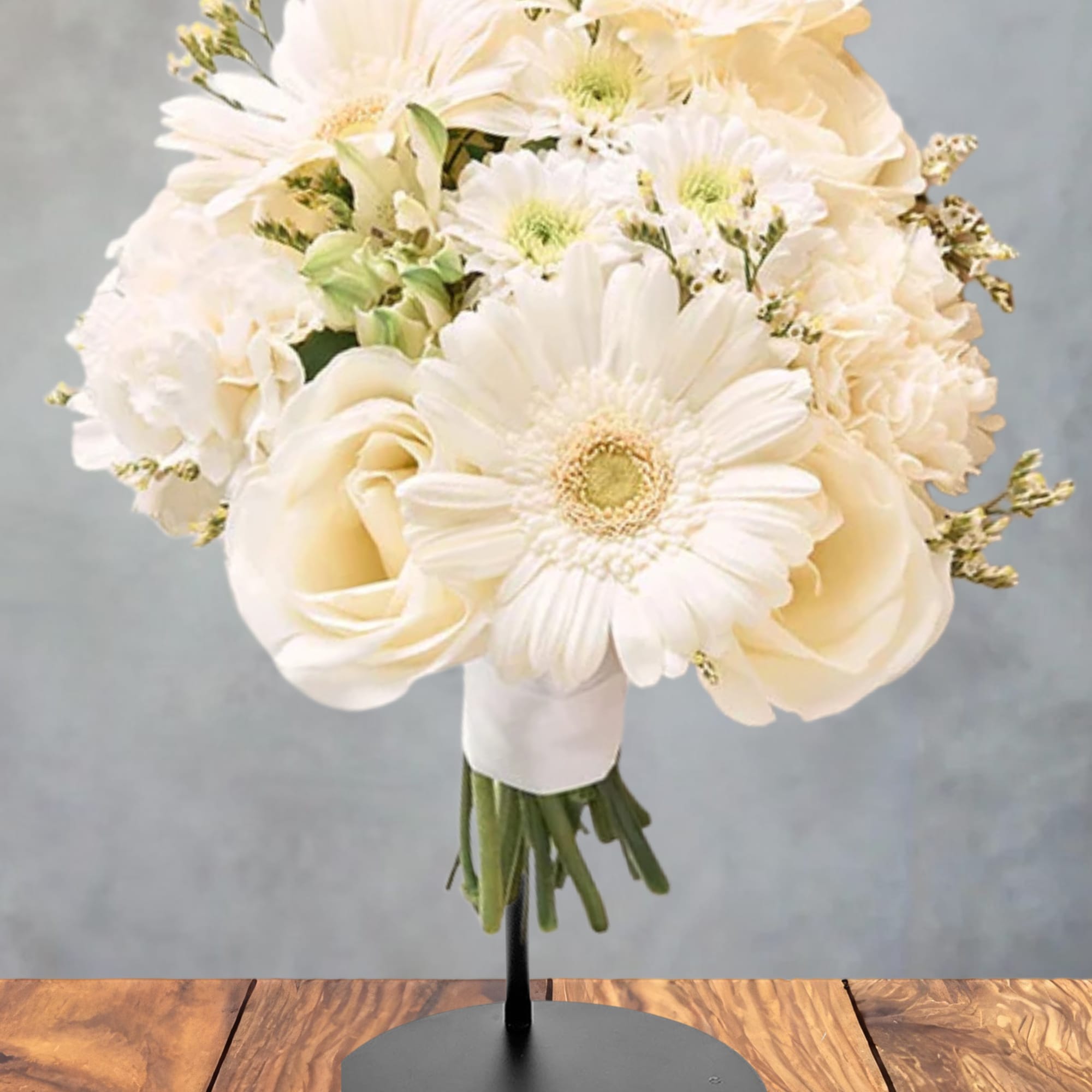 Cream bouquet of gerbera daisies and roses on a stand