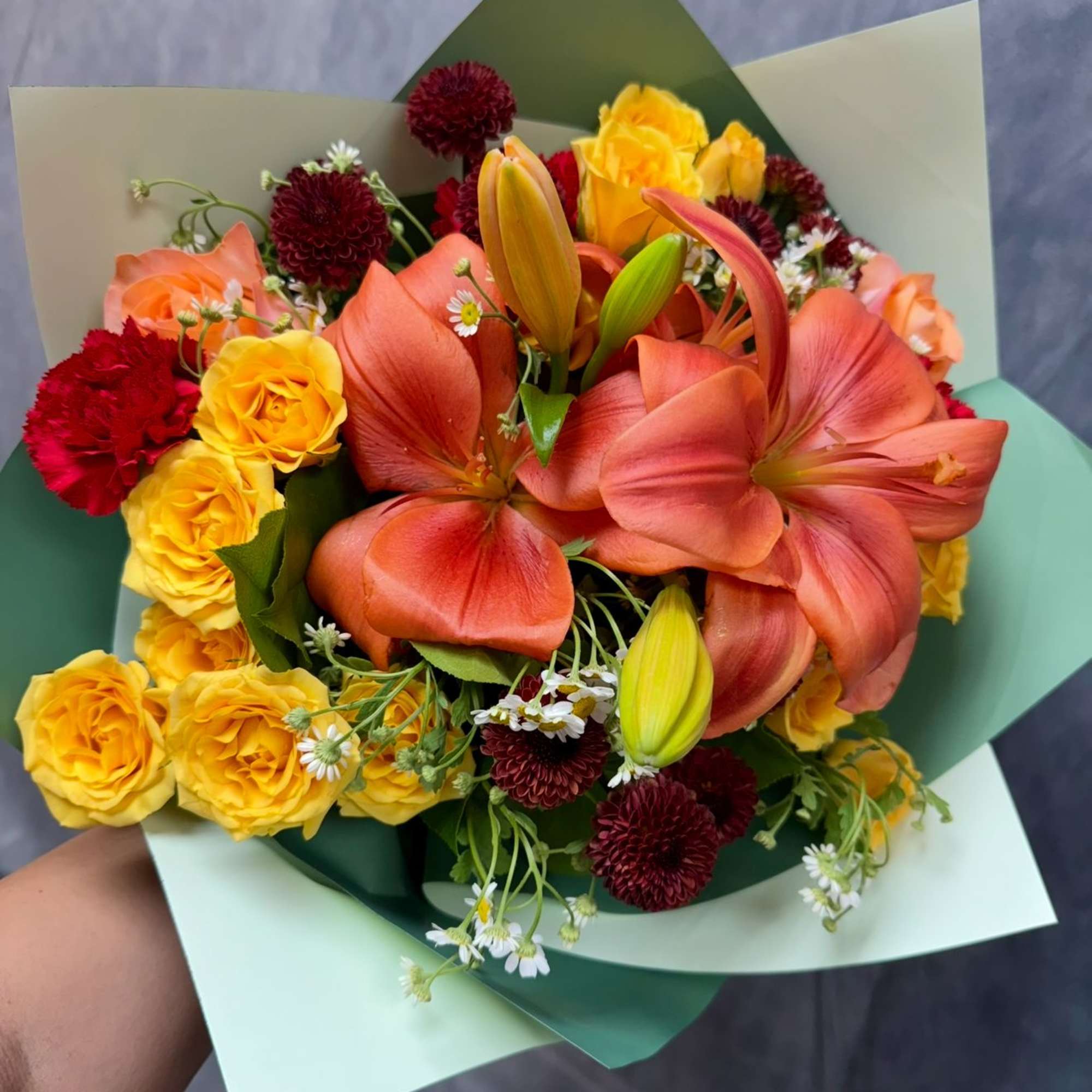 A flowing autumn bouquet featuring lilies, spray roses and seasonal blooms in
