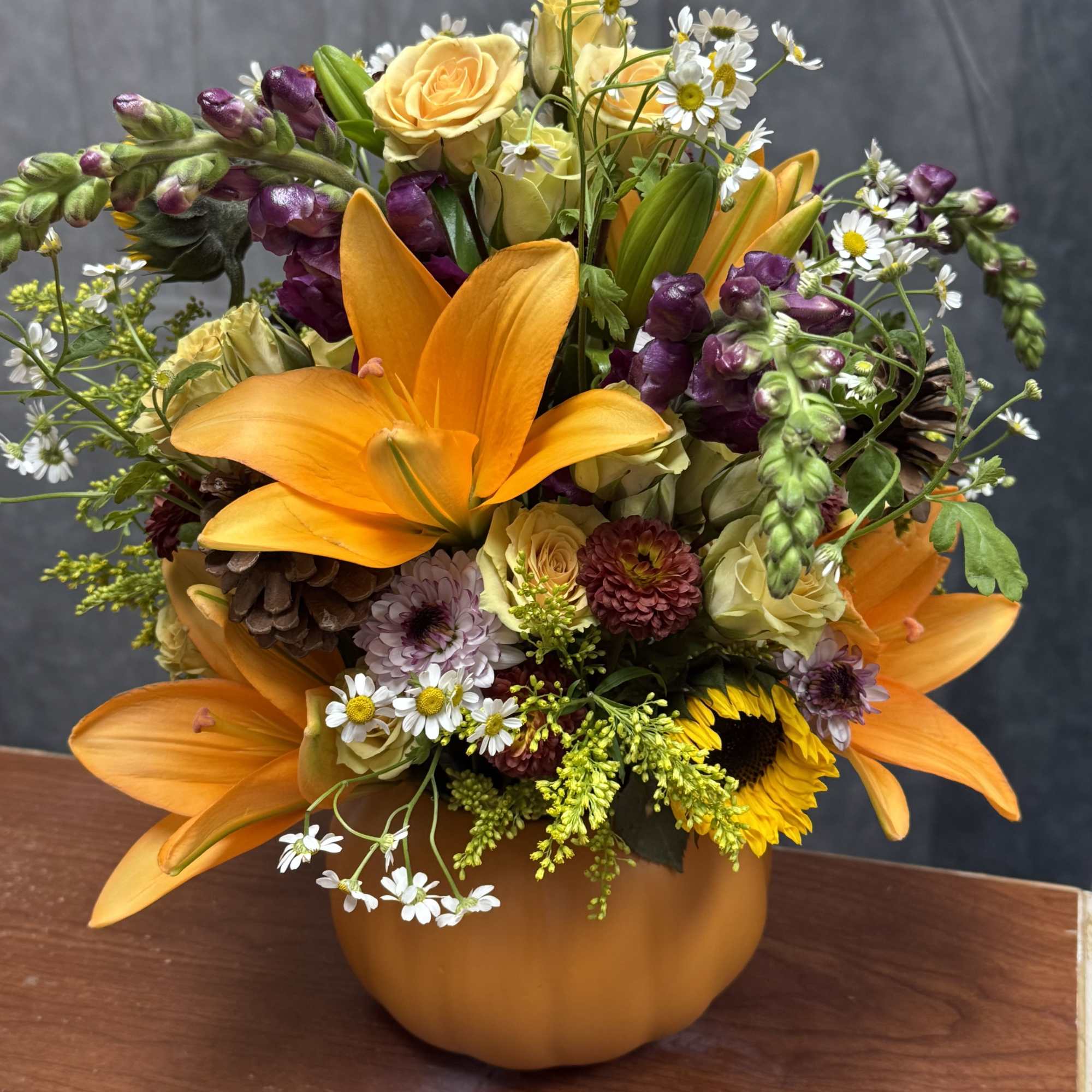 Bring fall into your home with this vibrant pumpkin arrangement filled with