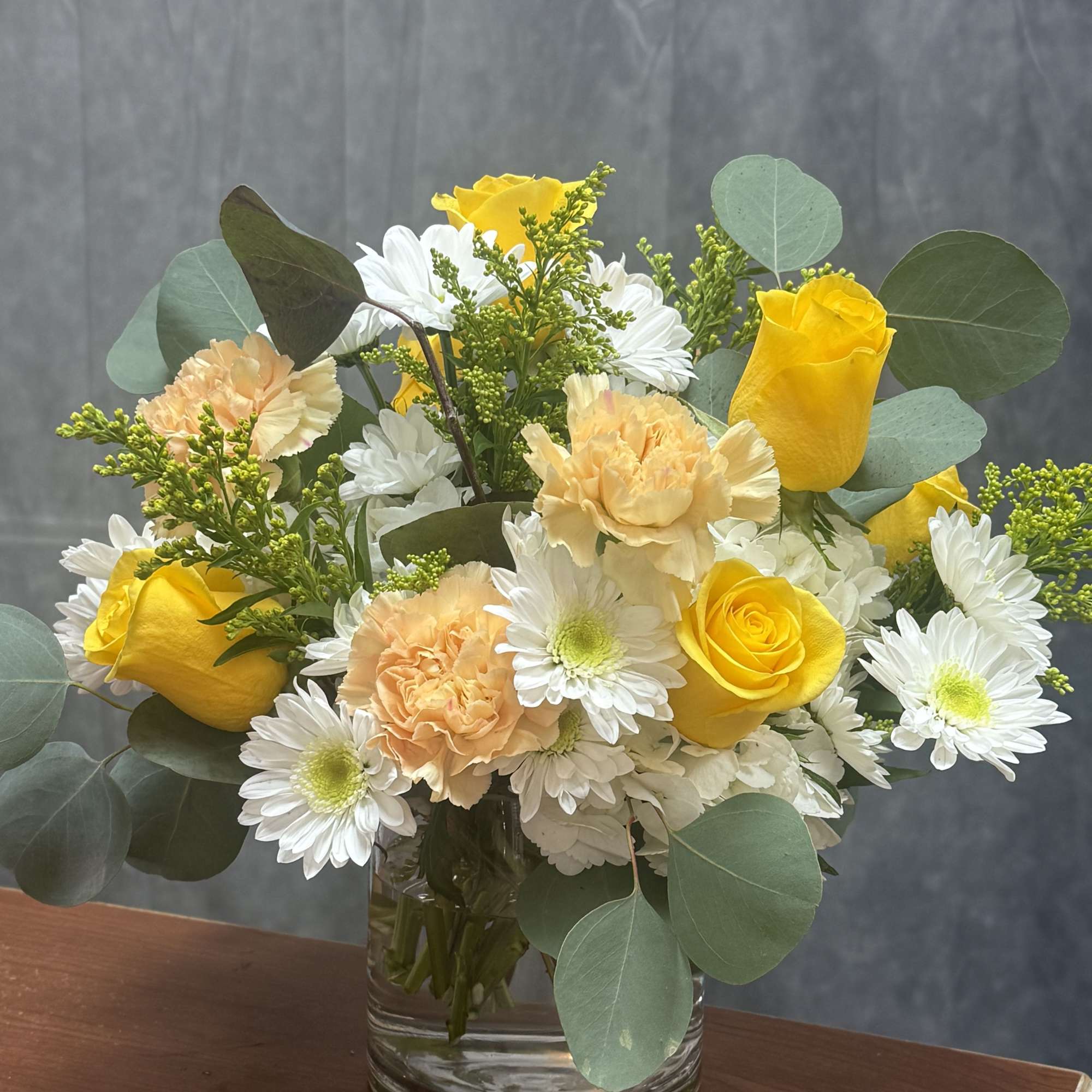 A vibrant arrangement of roses and carnations and delicate filler ,creating a