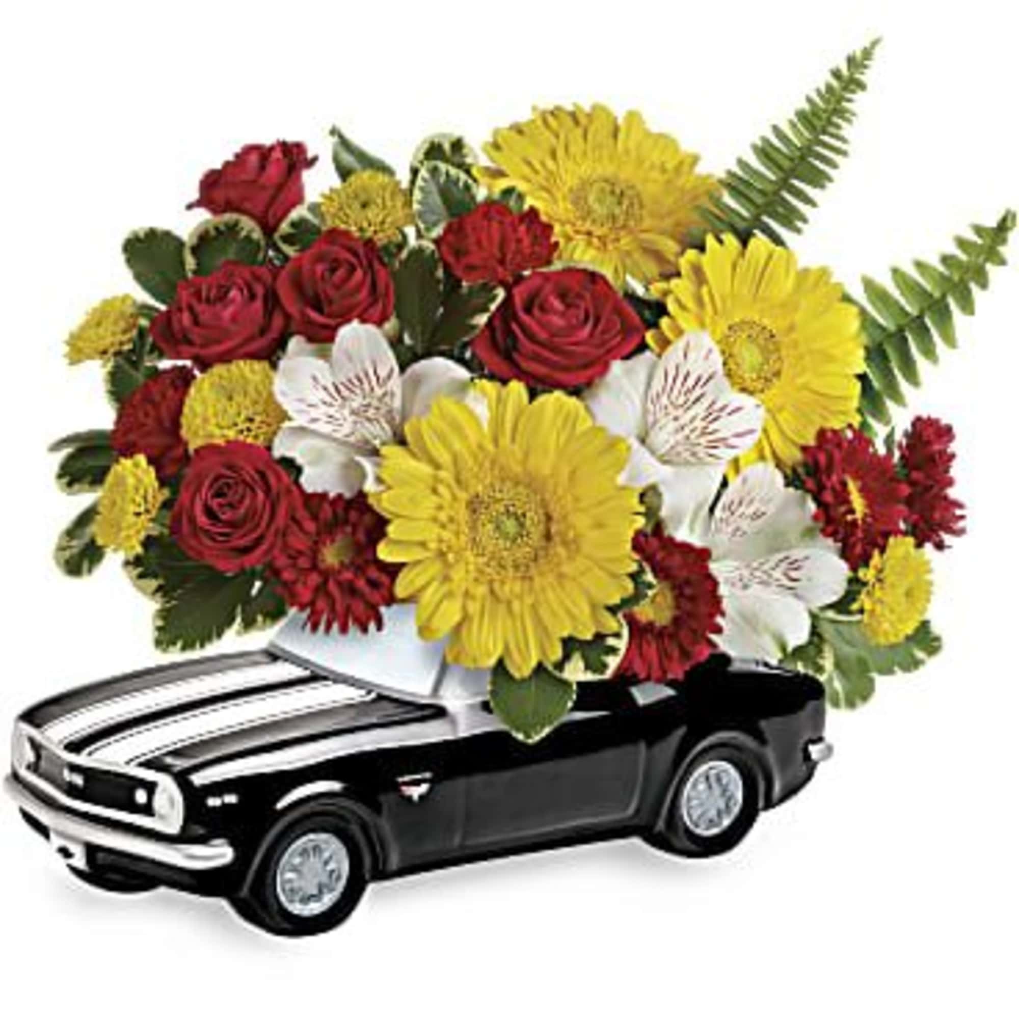 Bouquet of red roses, yellow daisies, and white flowers arranged on a black toy car