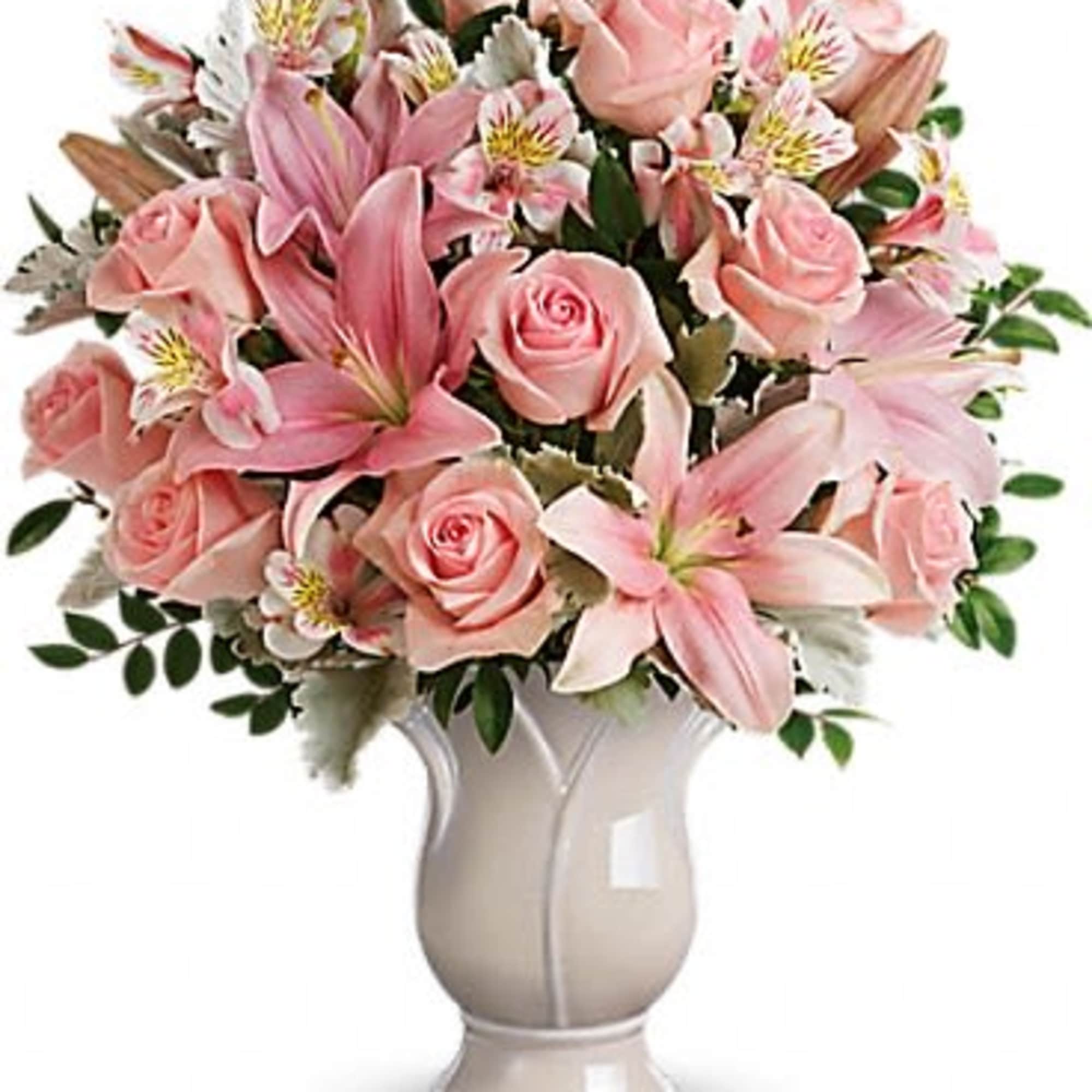 Pink roses and lilies arranged in a white vase