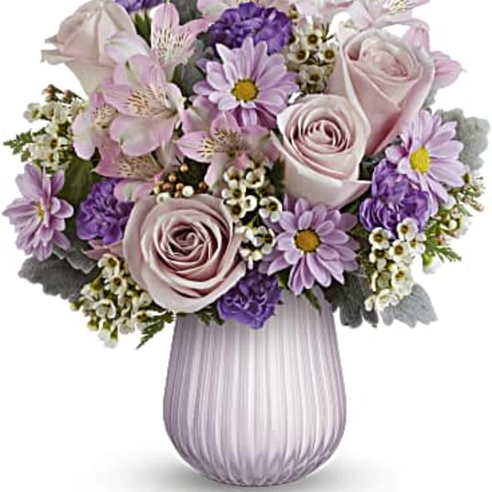 Pastel pink and lavender bouquet with roses, daisies, and alstroemeria arranged in a ribbed lavender vase.