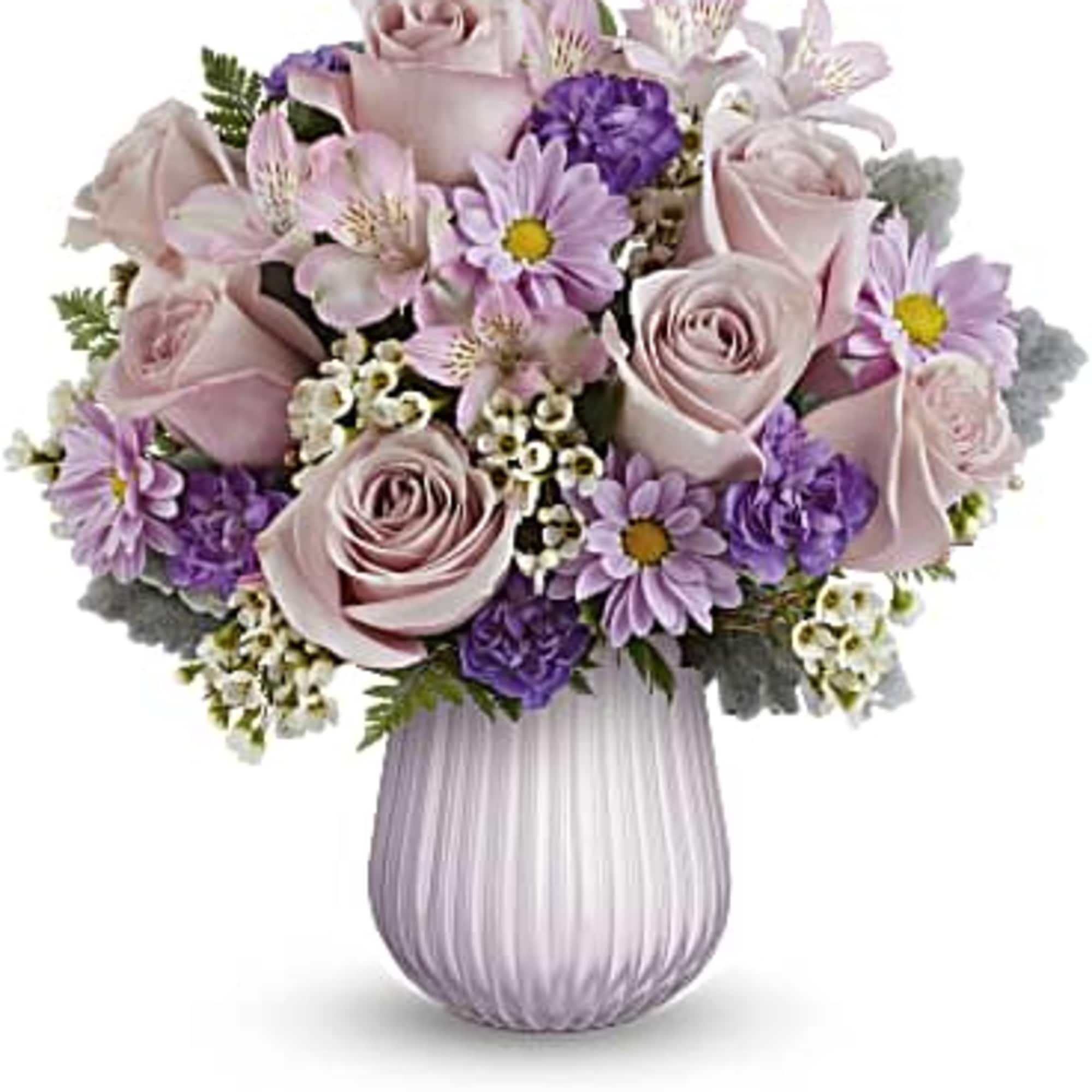 Lavender and pink rose and daisy arrangement in a ribbed pale purple glass vase