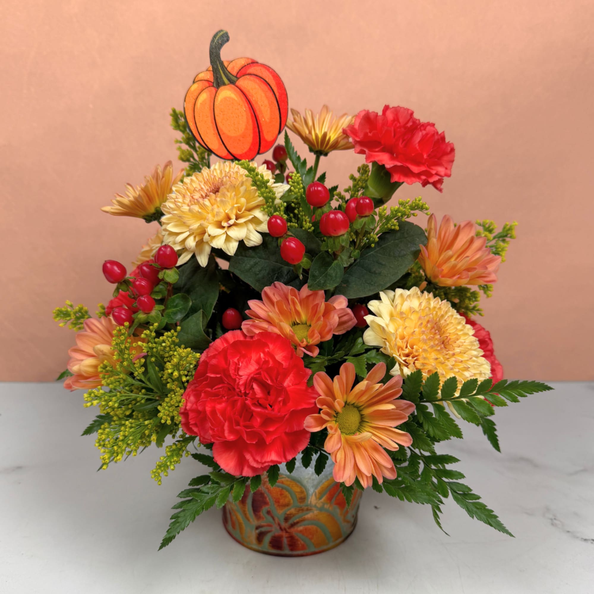 Autumn bouquet in a pumpkin vase with red and orange flowers