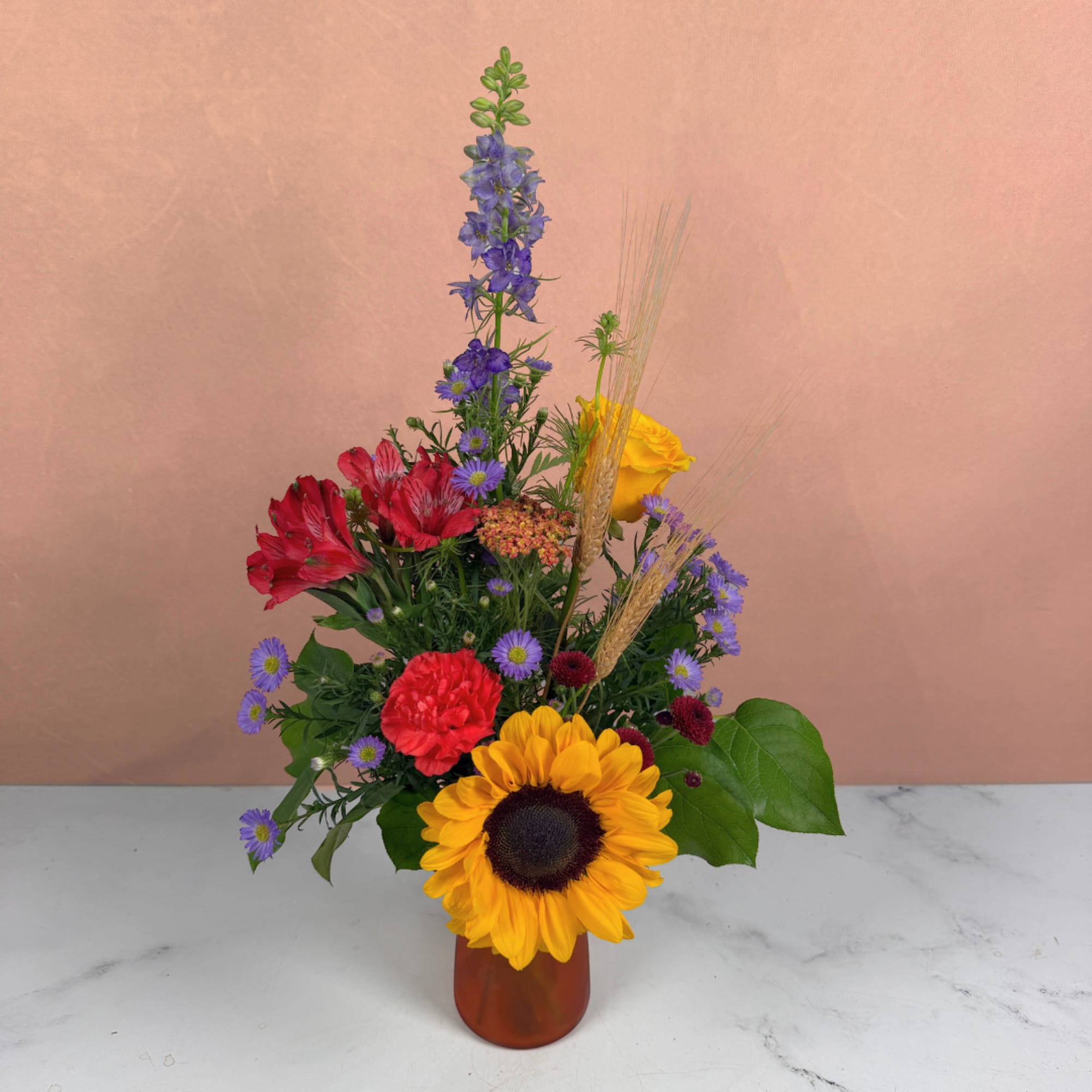 Mixed bouquet with a sunflower, red and yellow blooms in a vase