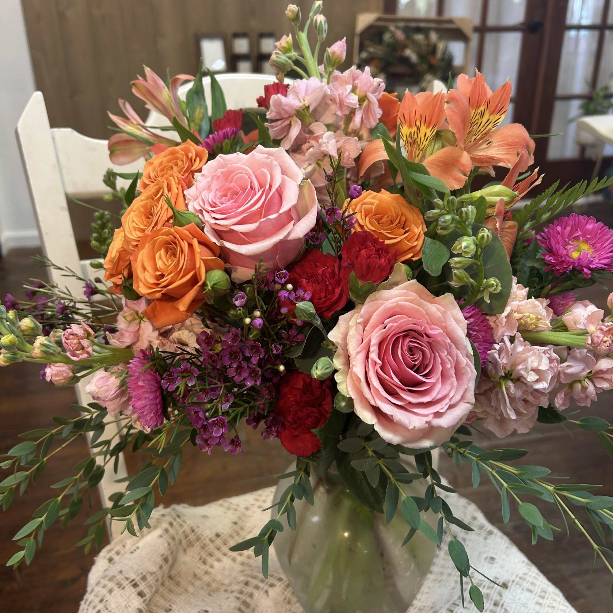 Mixed bouquet of pink and orange flowers in a glass vase