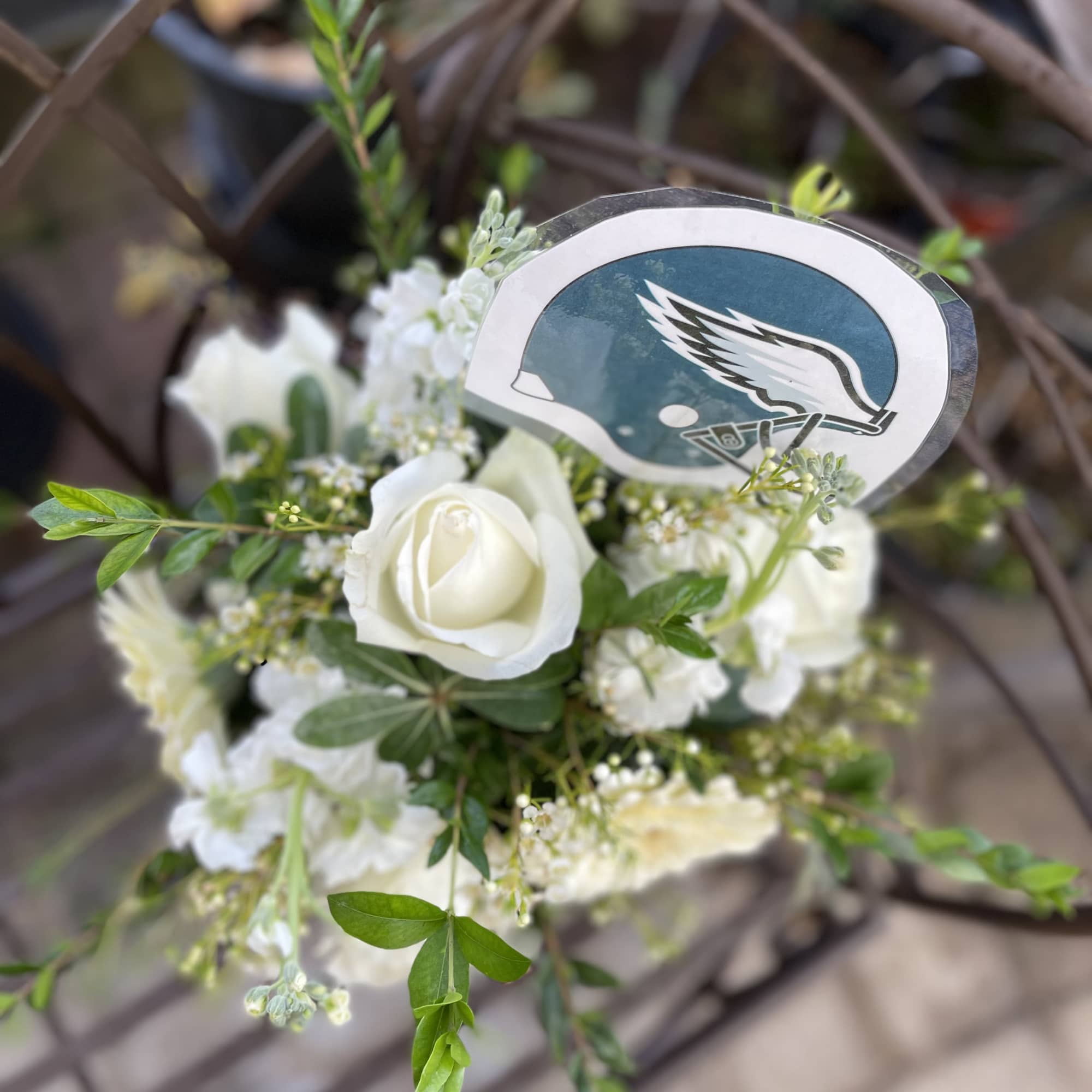 White rose bouquet with a football helmet pick