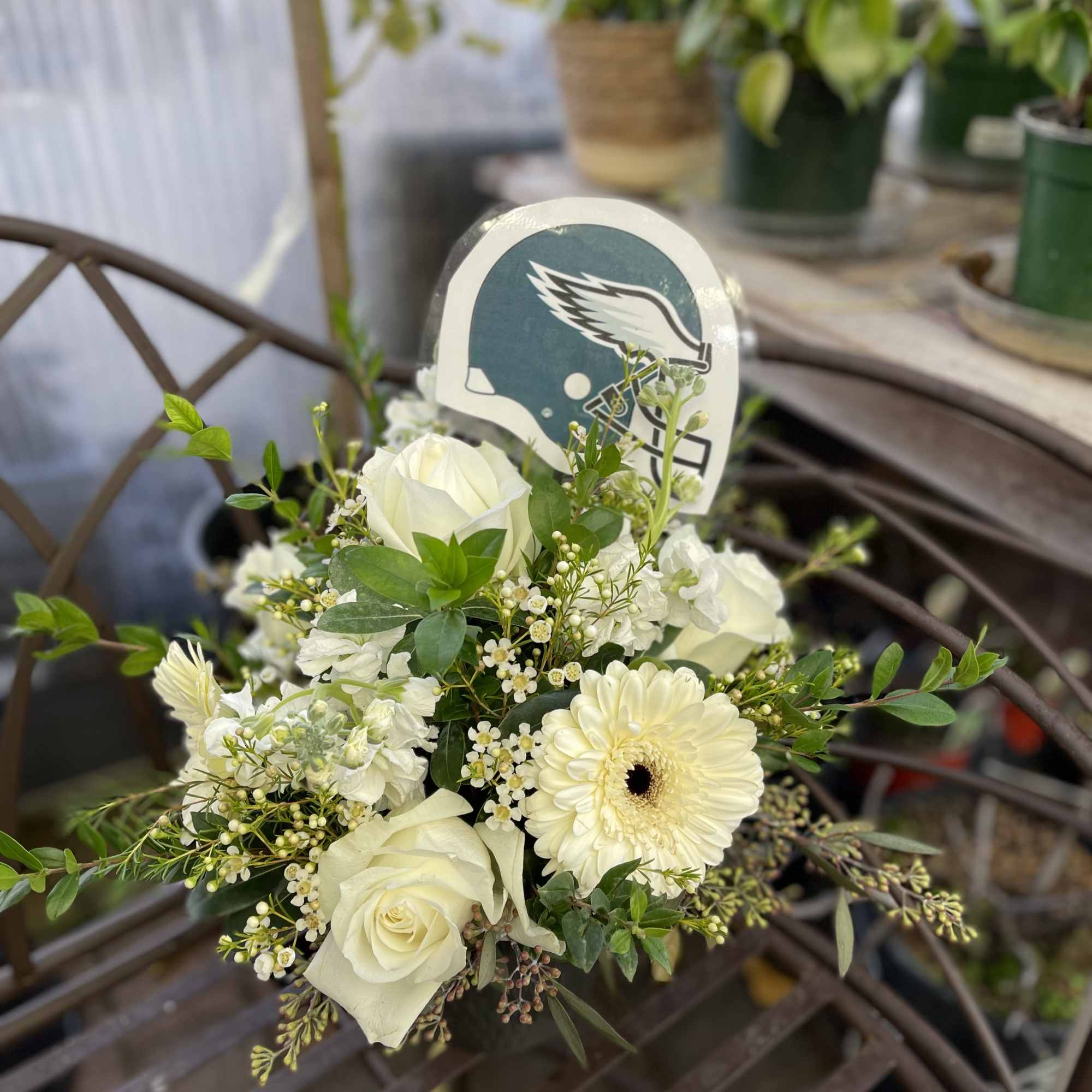 White rose and gerbera bouquet with a football helmet pick