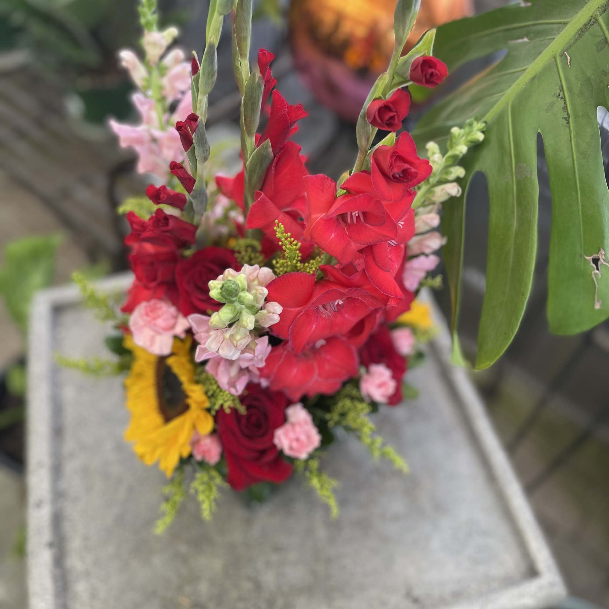 Bright red gladiolus bouquet with roses and a sunflower