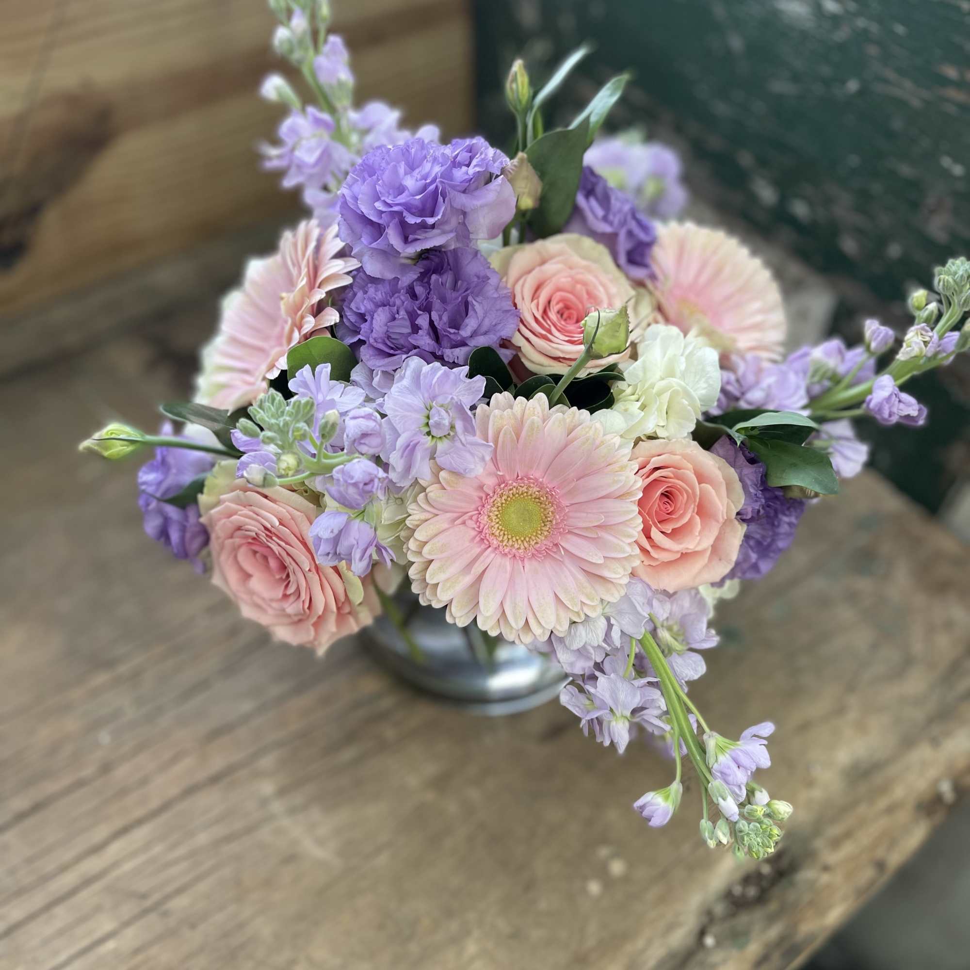 Pastel bouquet with pink roses, a gerbera daisy, and lavender flowers in a vase