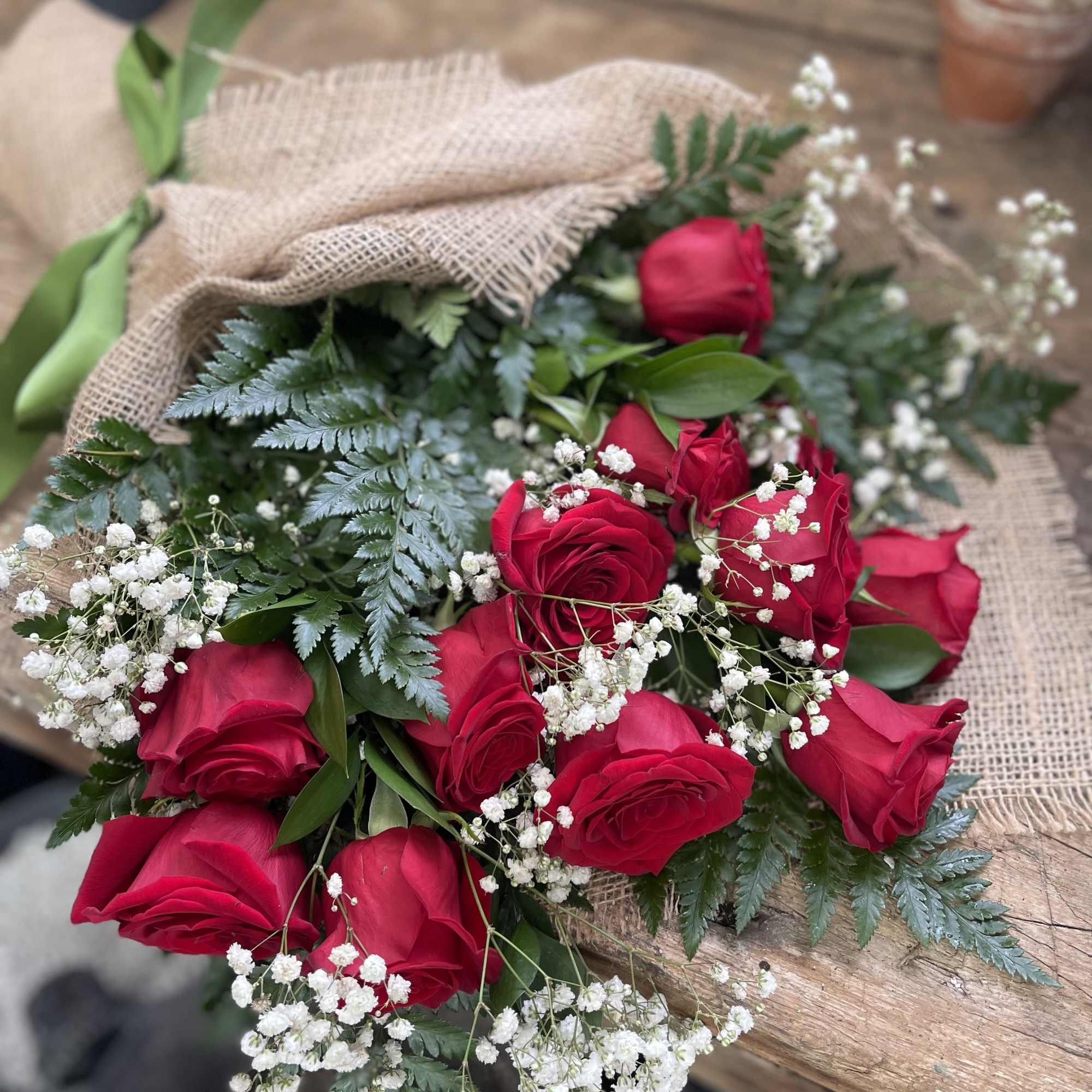 Bouquet of red roses with baby's breath wrapped in burlap
