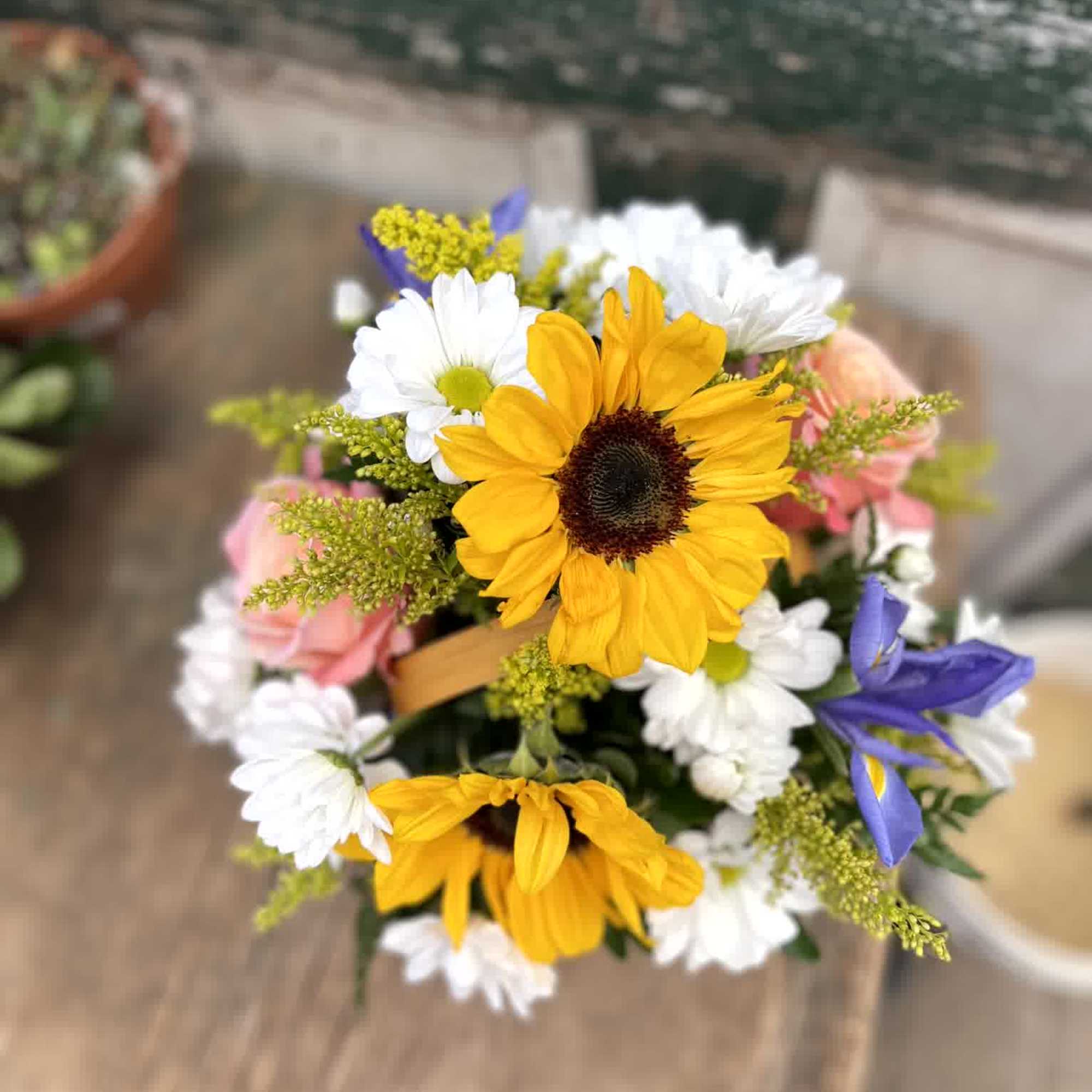 Bouquet of yellow sunflowers and white daisies with pink and purple accents
