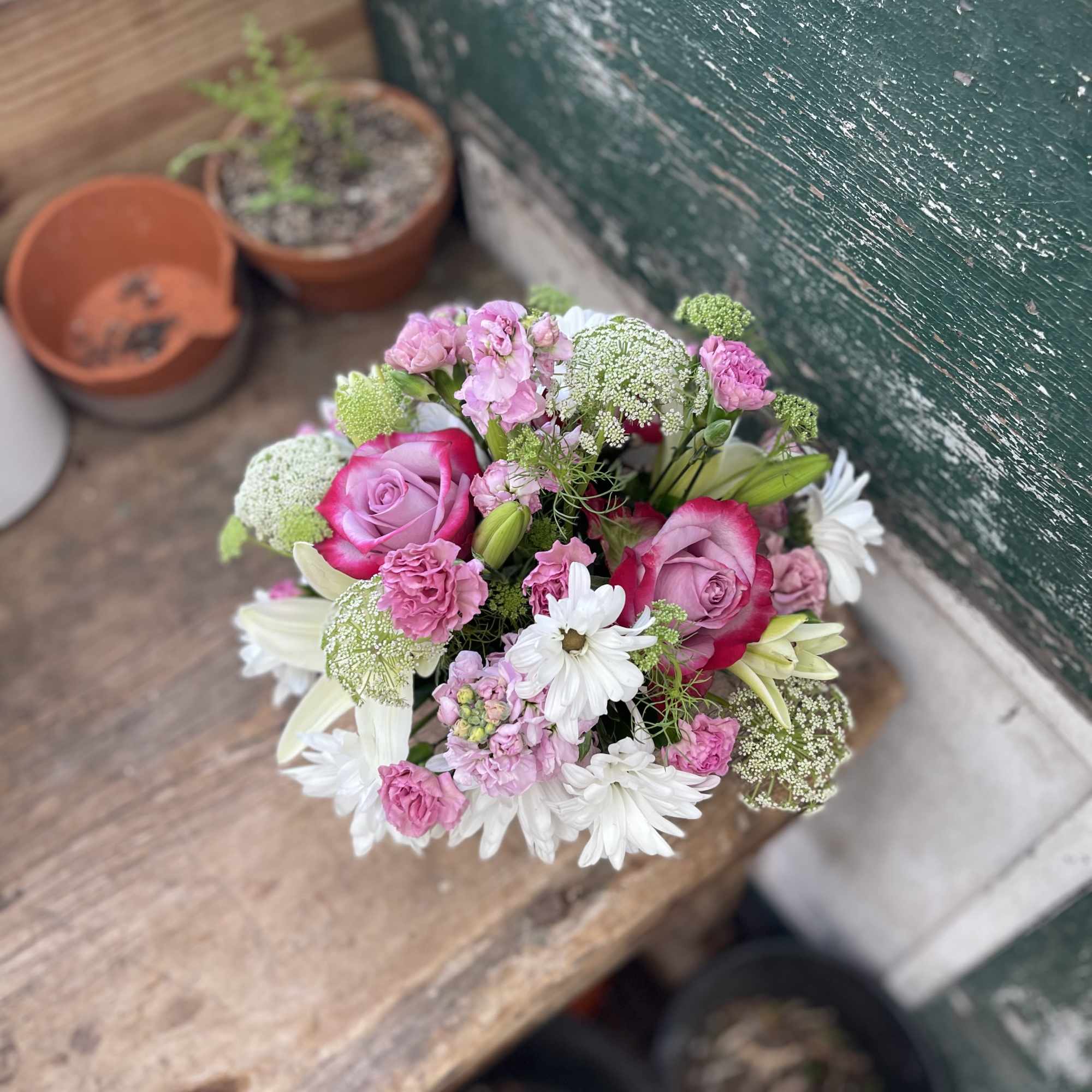Round bouquet of pink roses and white daisies