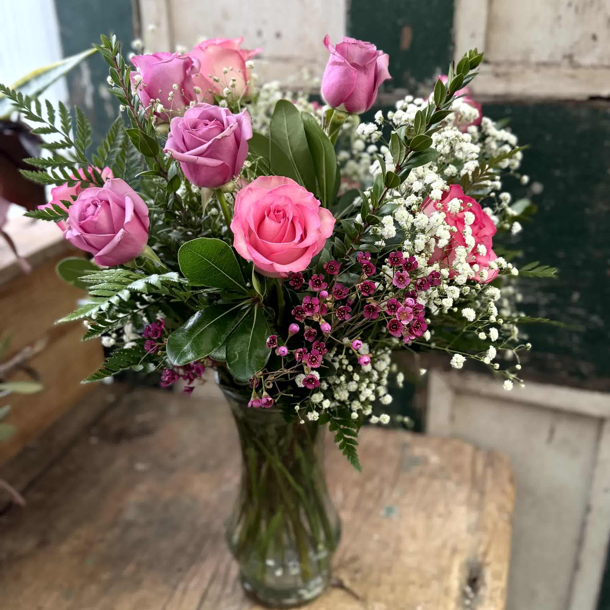 Pink roses and white baby's breath in a clear glass vase