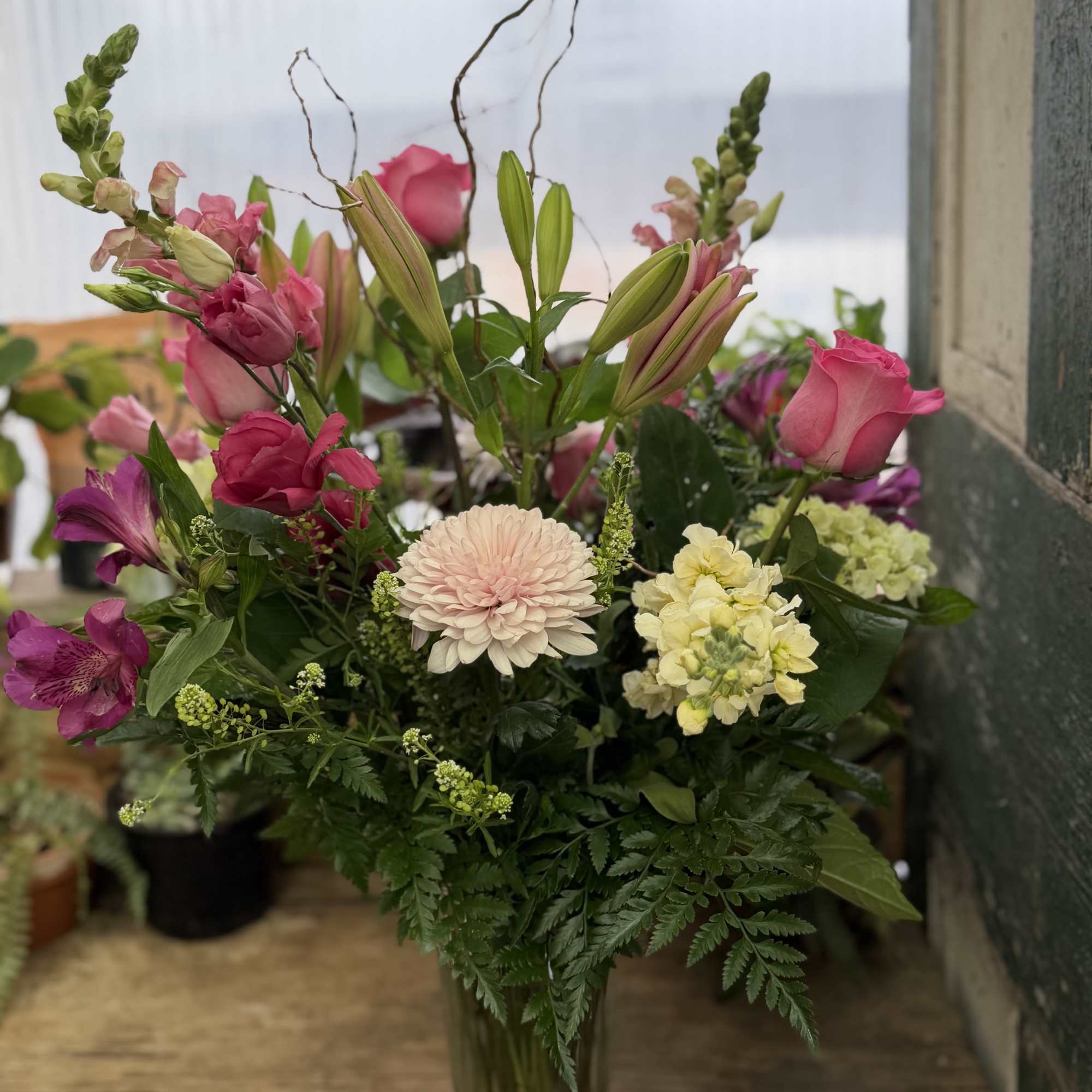 Mixed pink and cream floral arrangement in a clear glass vase