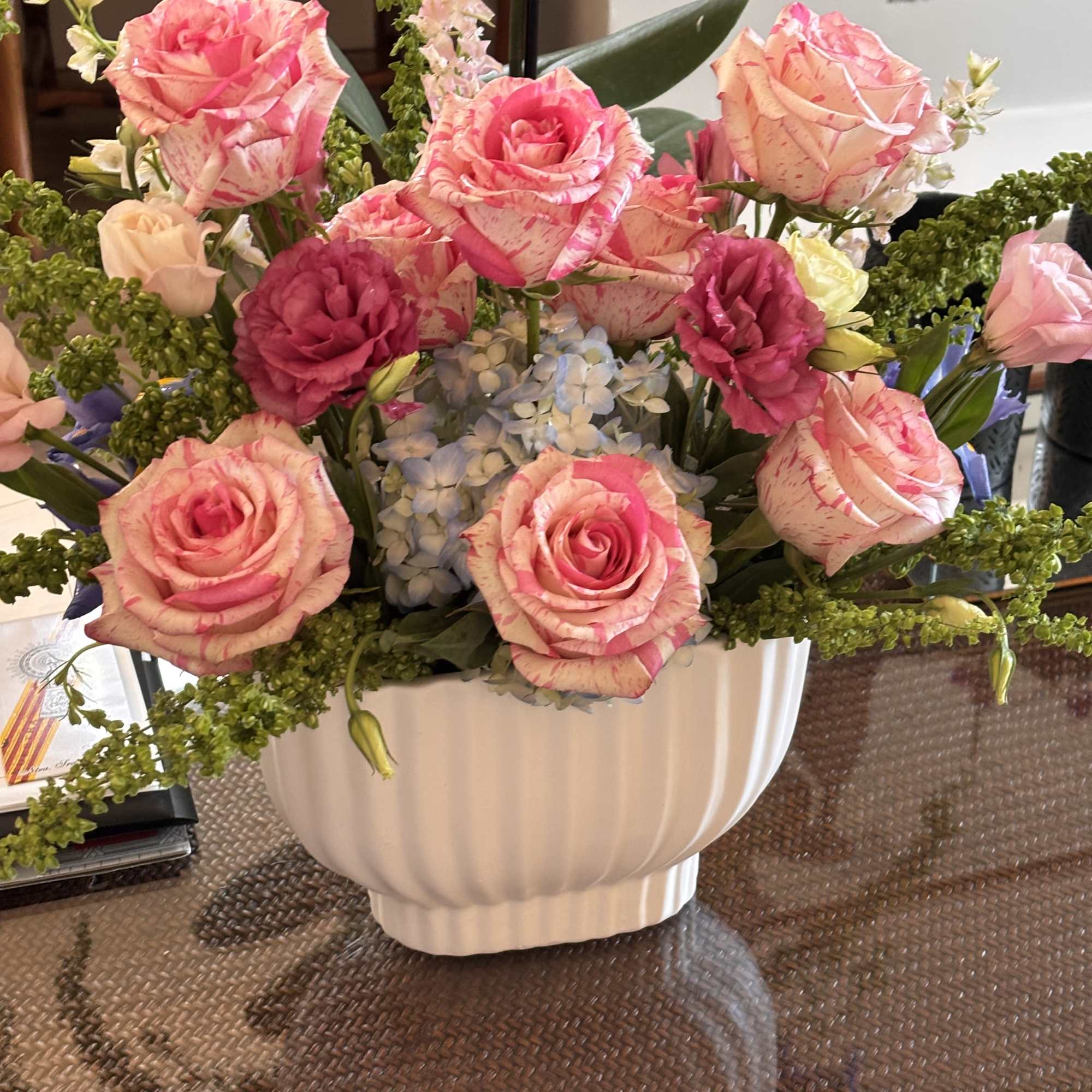 Pink and cream roses arranged in a white vase