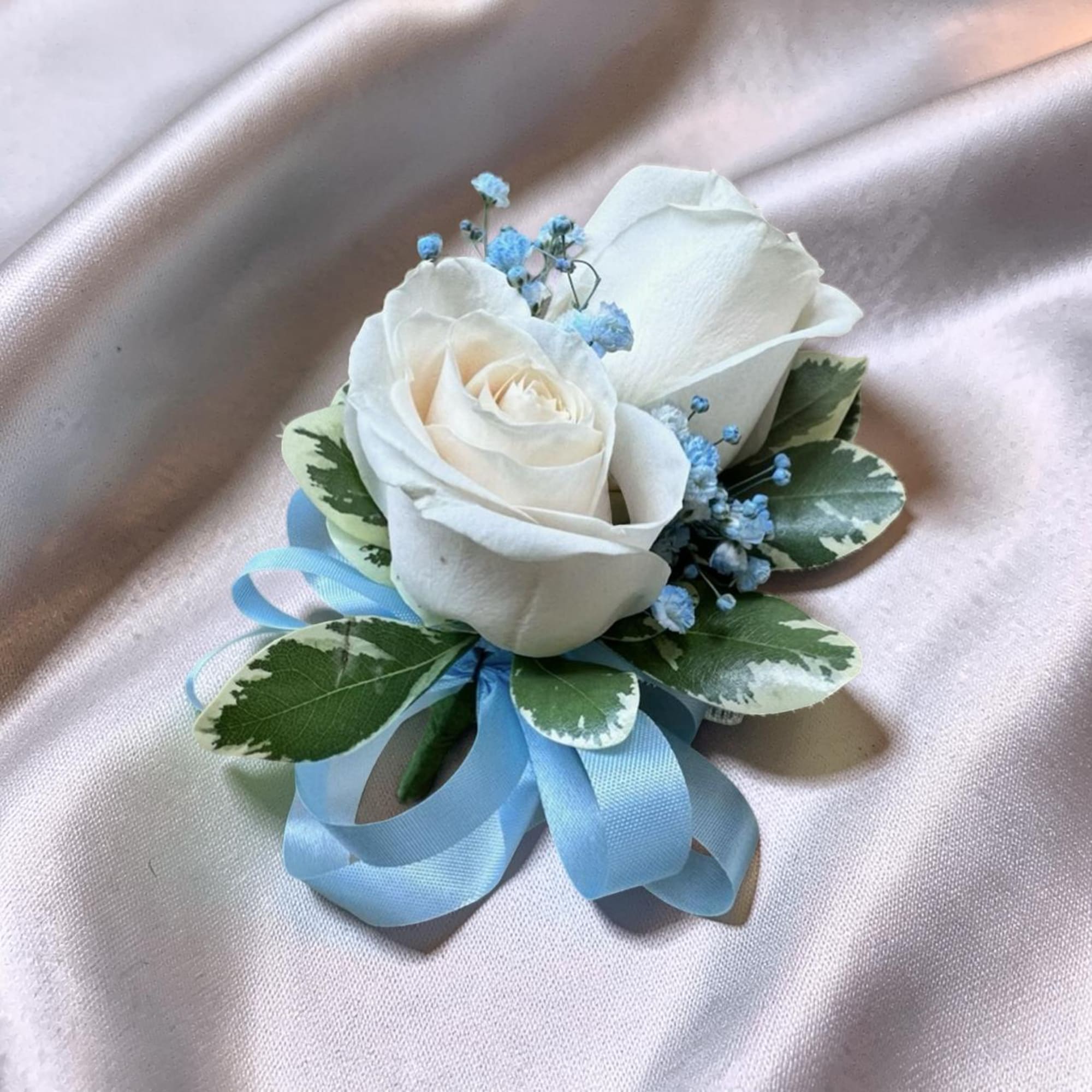 A classic white rose corsage with soft blue accents, finished with a, photo 2 of 2