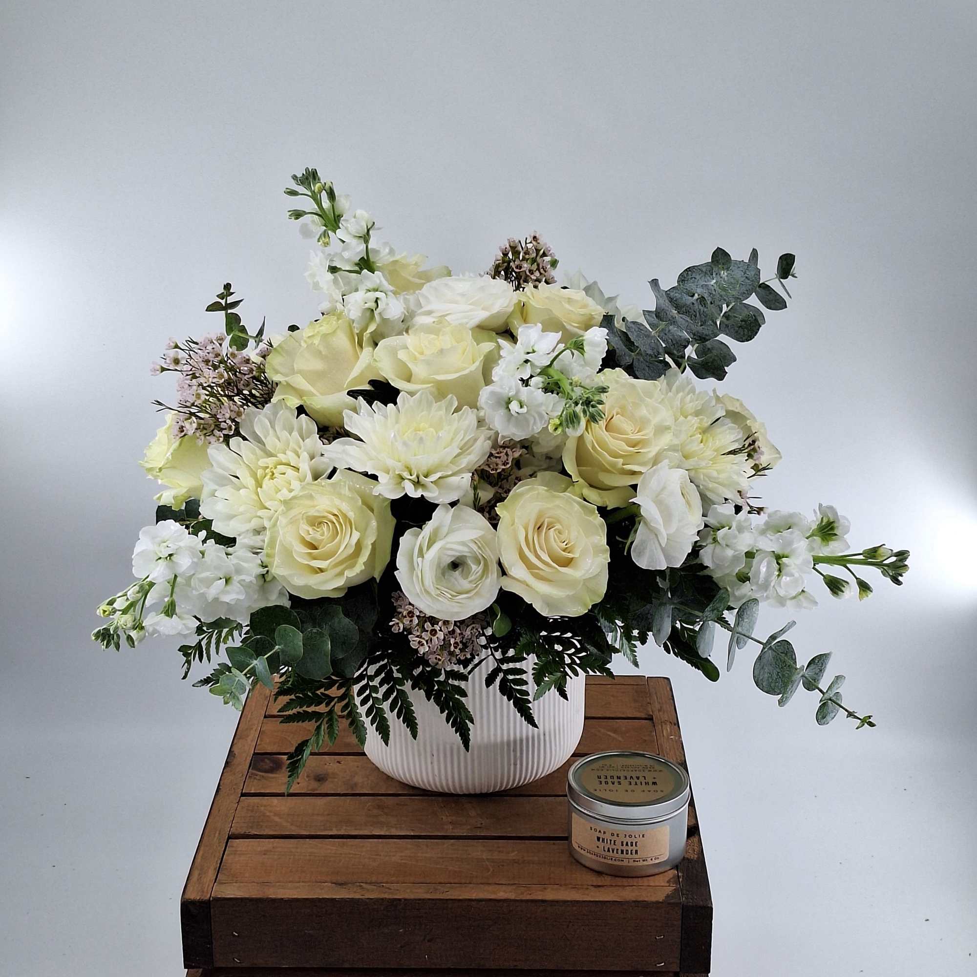 Cream rose bouquet in a white vase with eucalyptus and white blooms