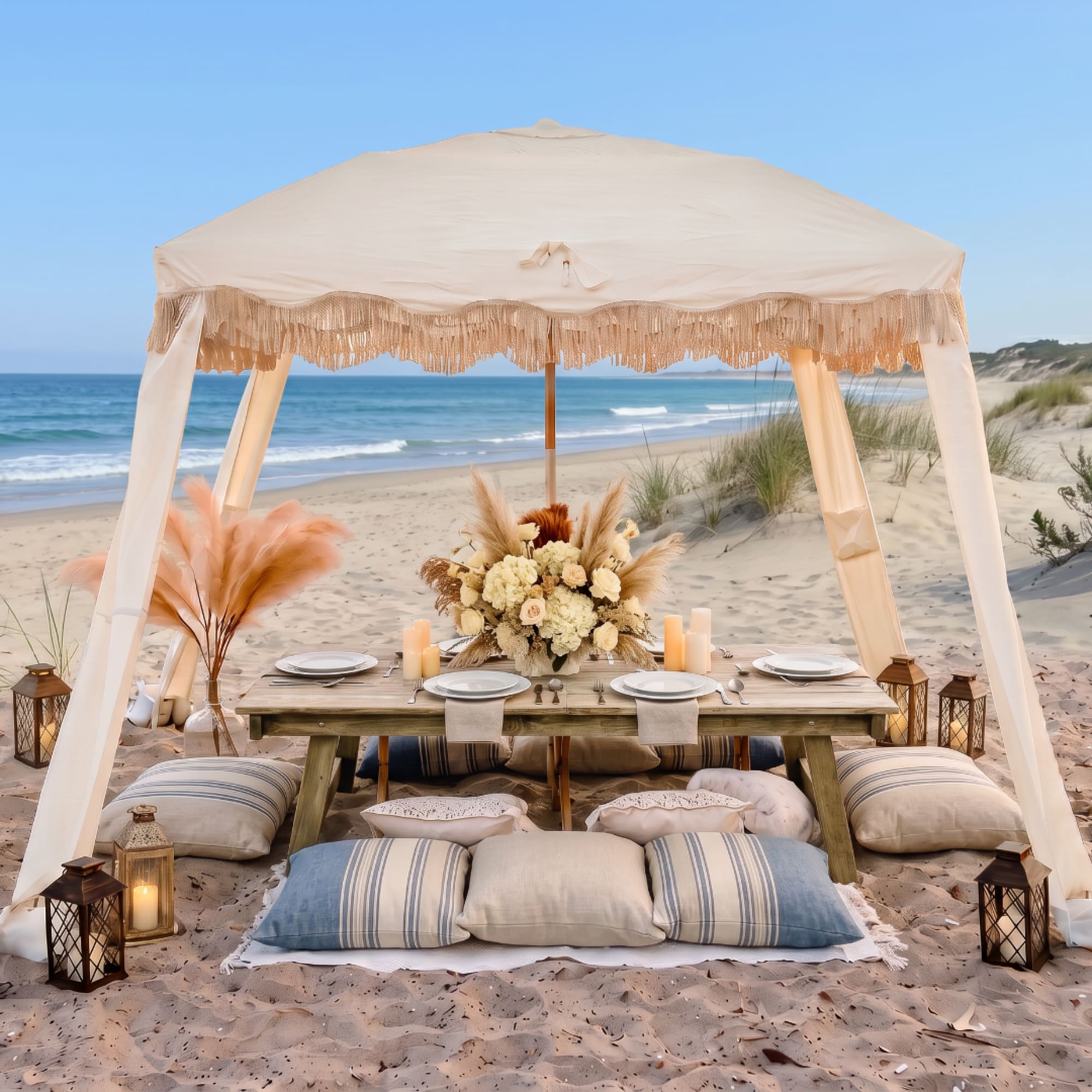 Beachside canopy dining setup with a floral centerpiece and lanterns