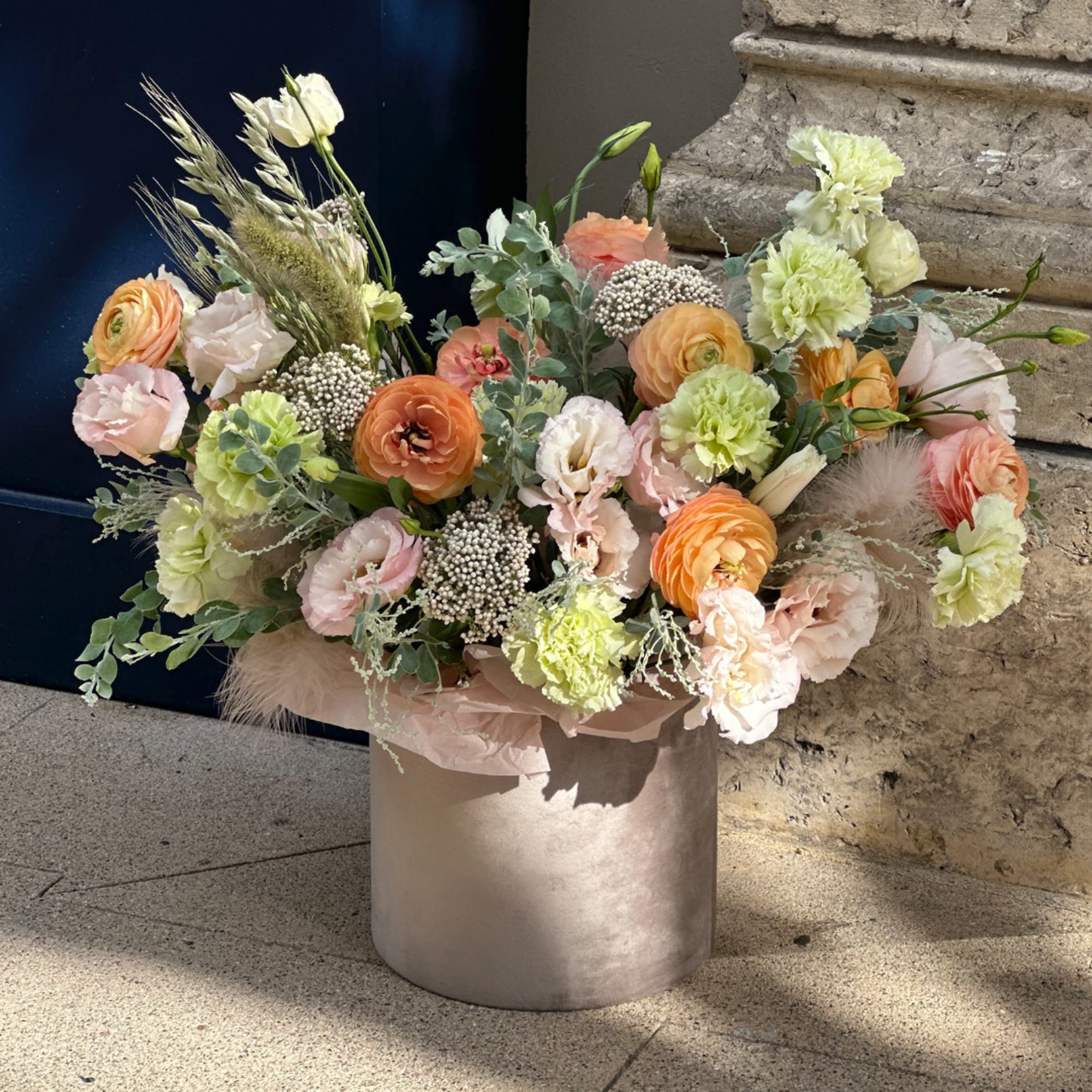 Pastel mixed flower arrangement in a round metallic vase