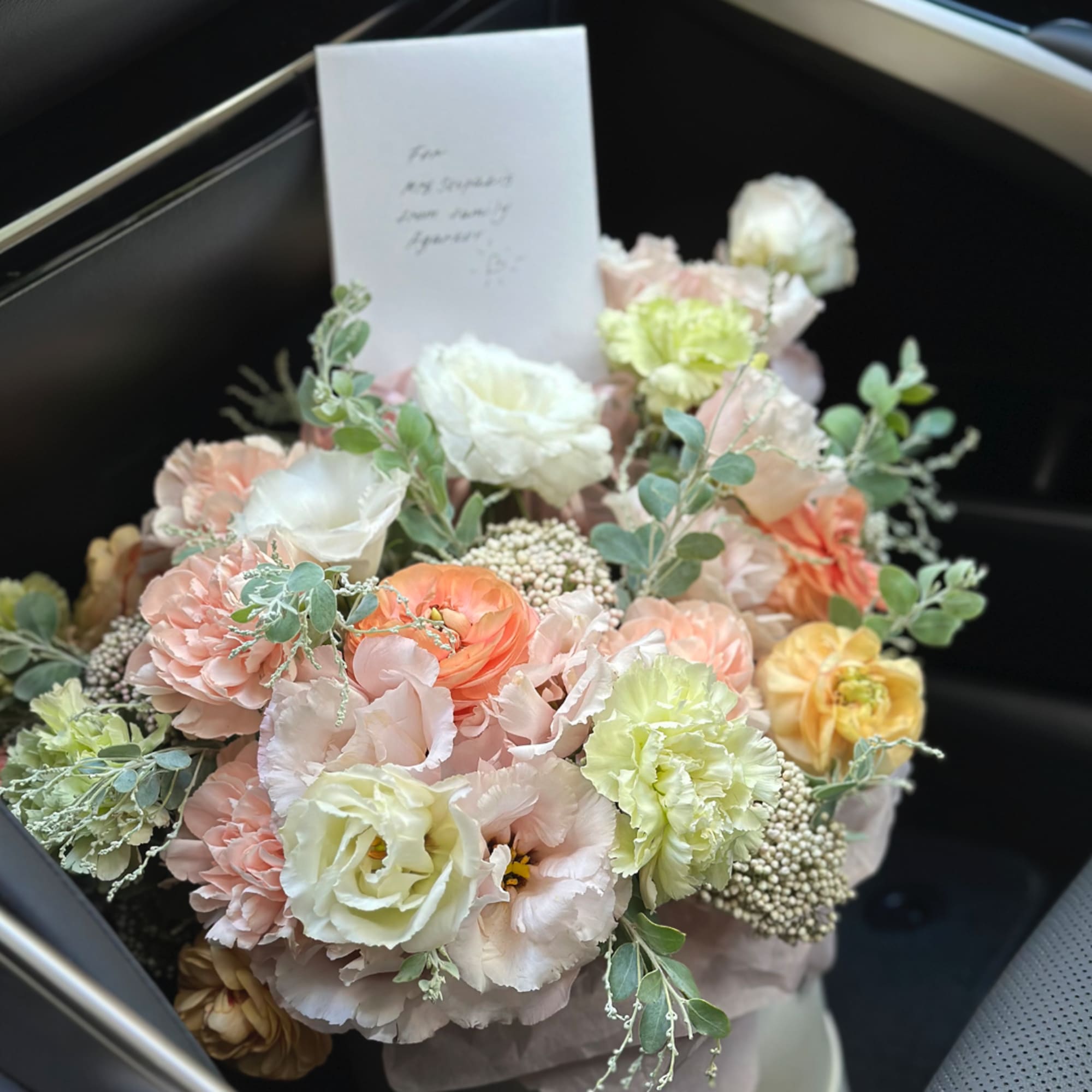 Pastel bouquet of roses and carnations with a card in a box