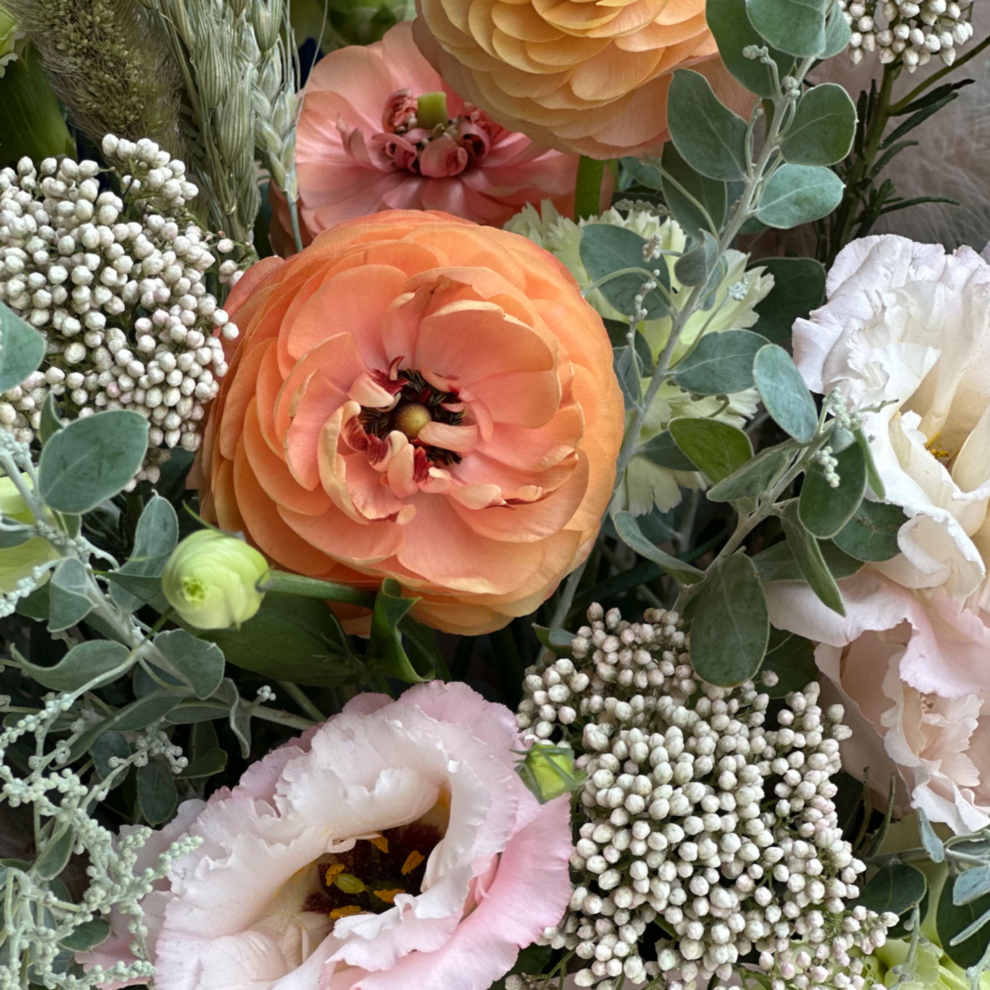 Peach and white flowers arranged with soft green foliage