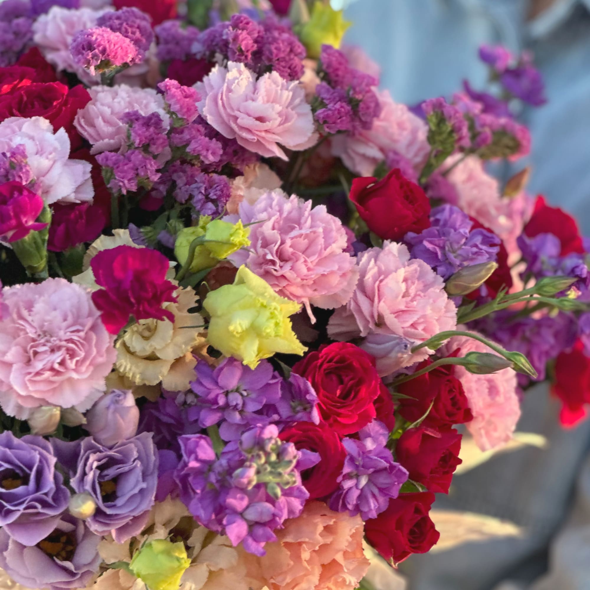 Bouquet of pink, purple, and red flowers with ruffled blooms