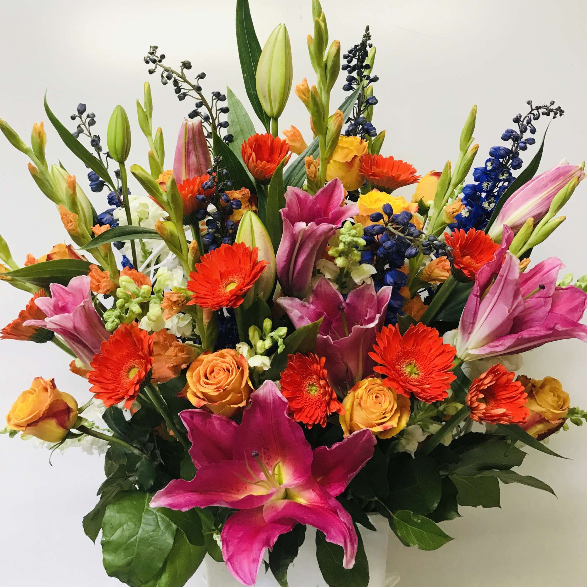 Bright mixed bouquet with pink lilies, orange gerberas, and yellow roses
