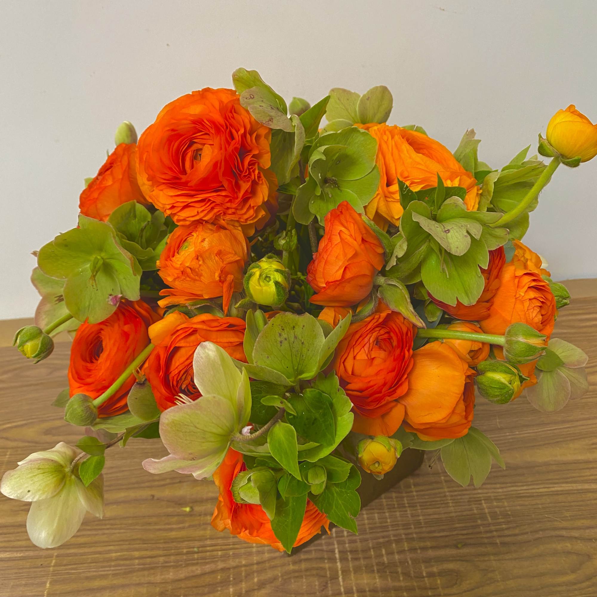 Bouquet of orange ranunculus with green blooms