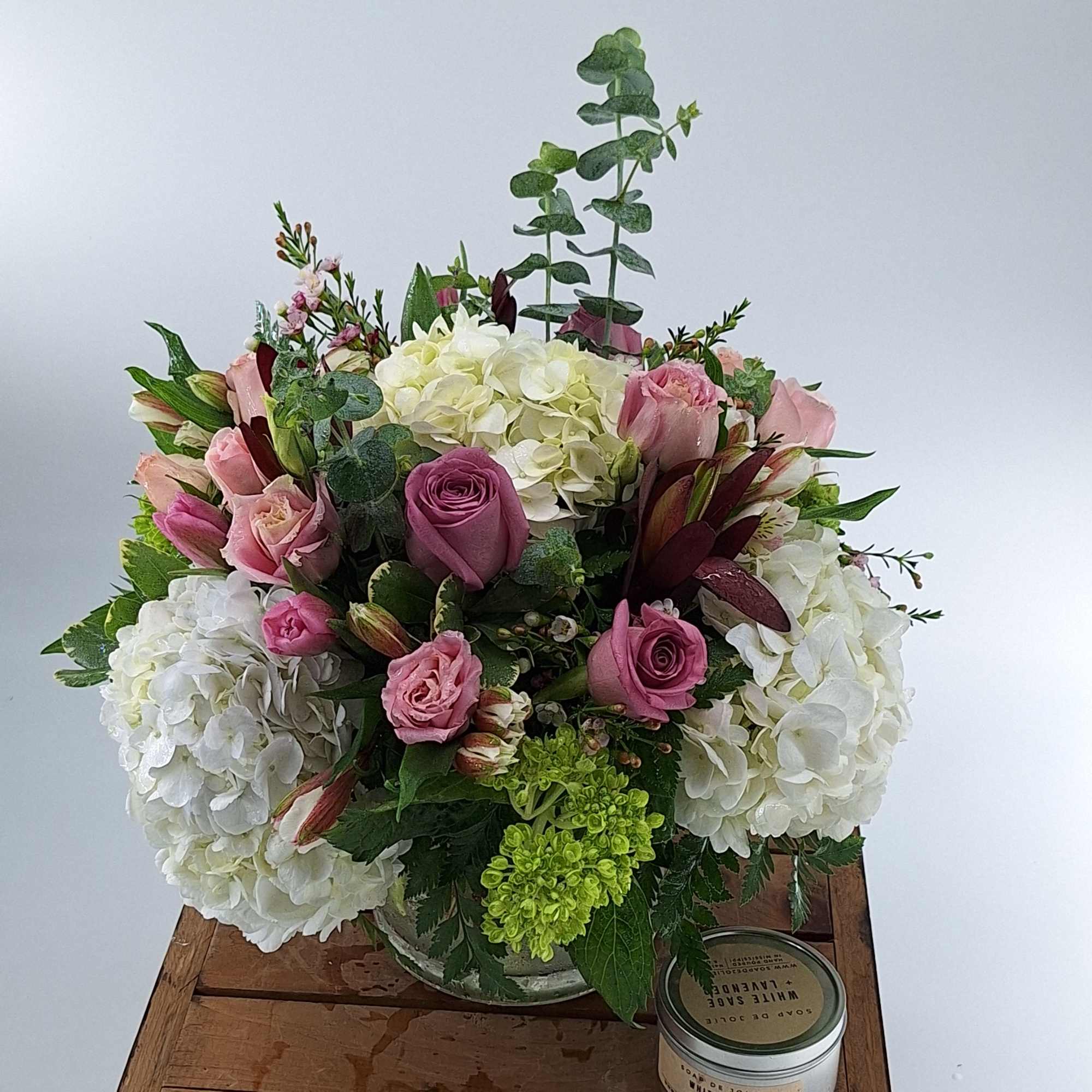 Pink roses and white hydrangeas in a low glass vase