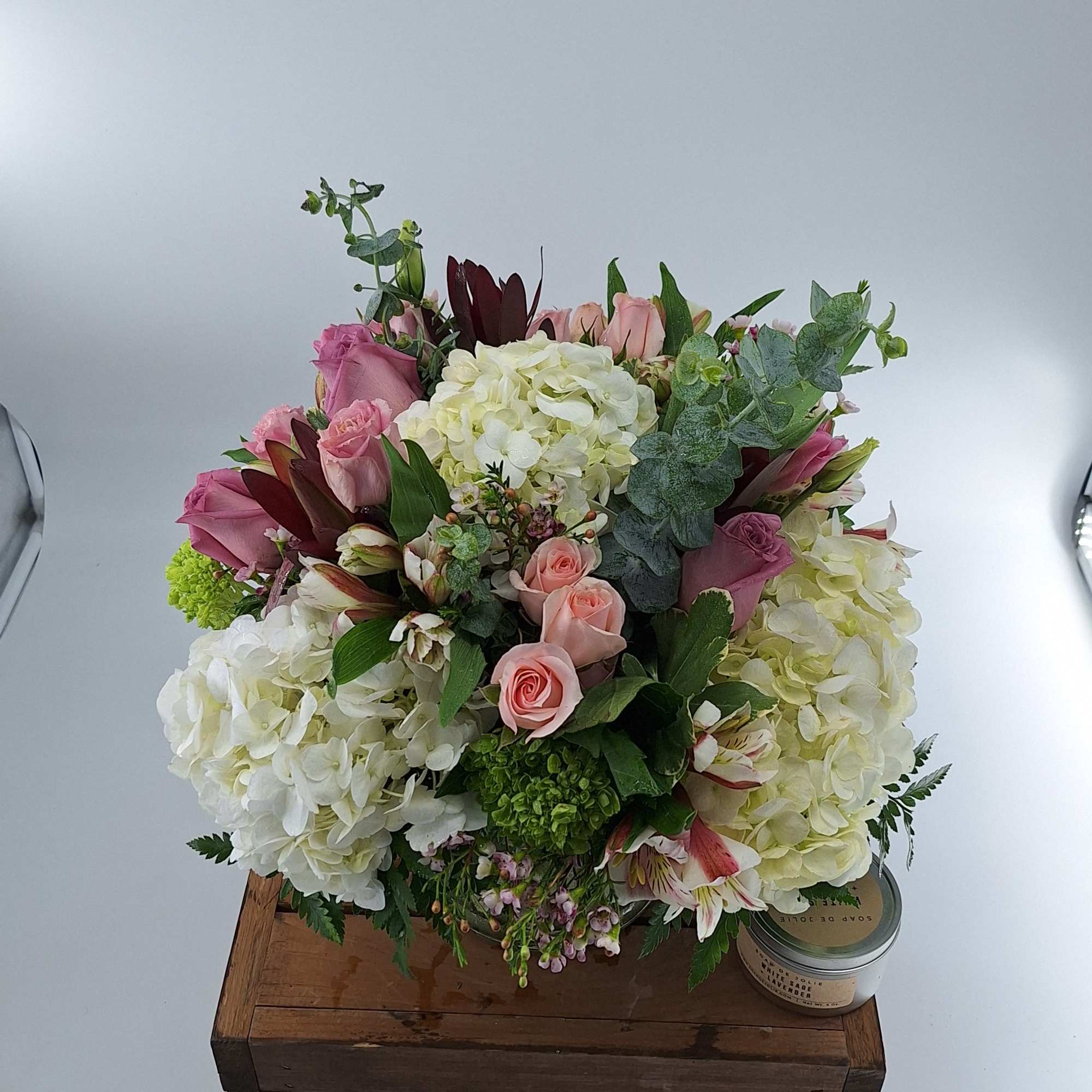 Pink and white mixed bouquet with hydrangeas and roses in a low container