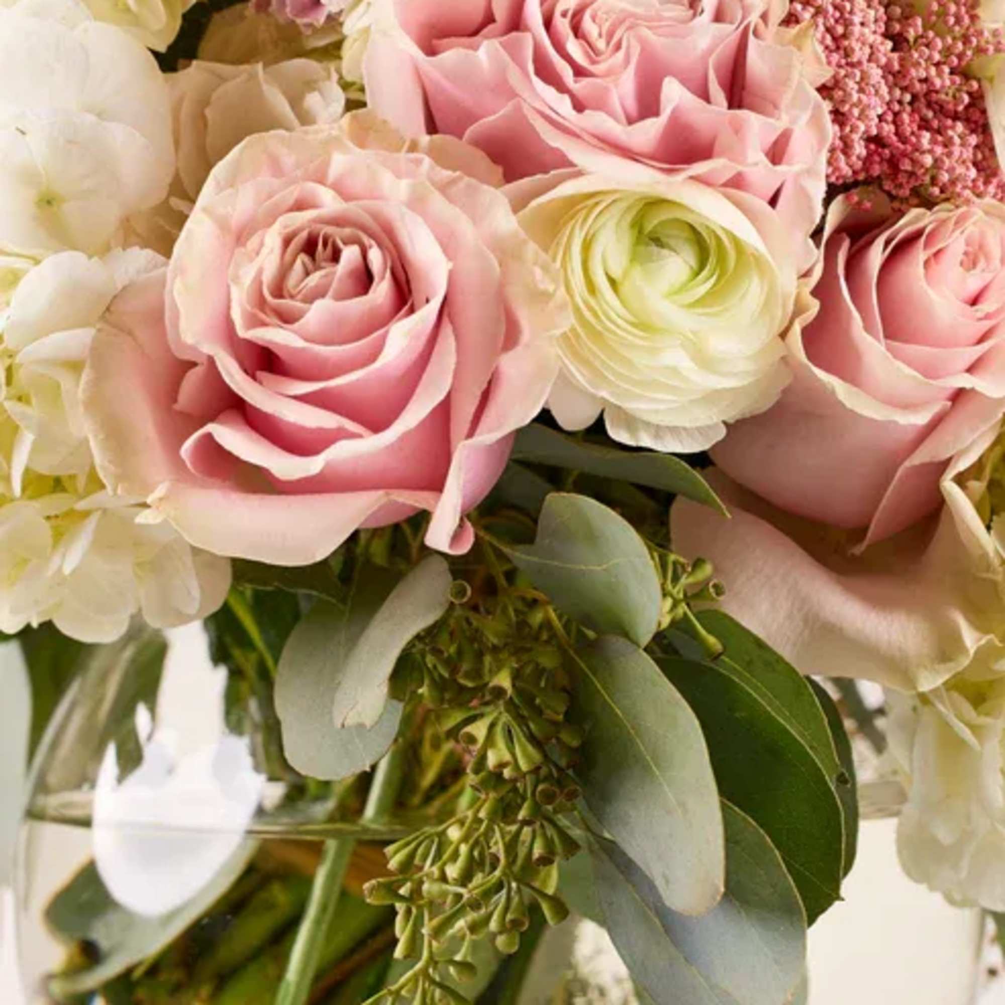 Pink roses and white blooms in a glass vase
