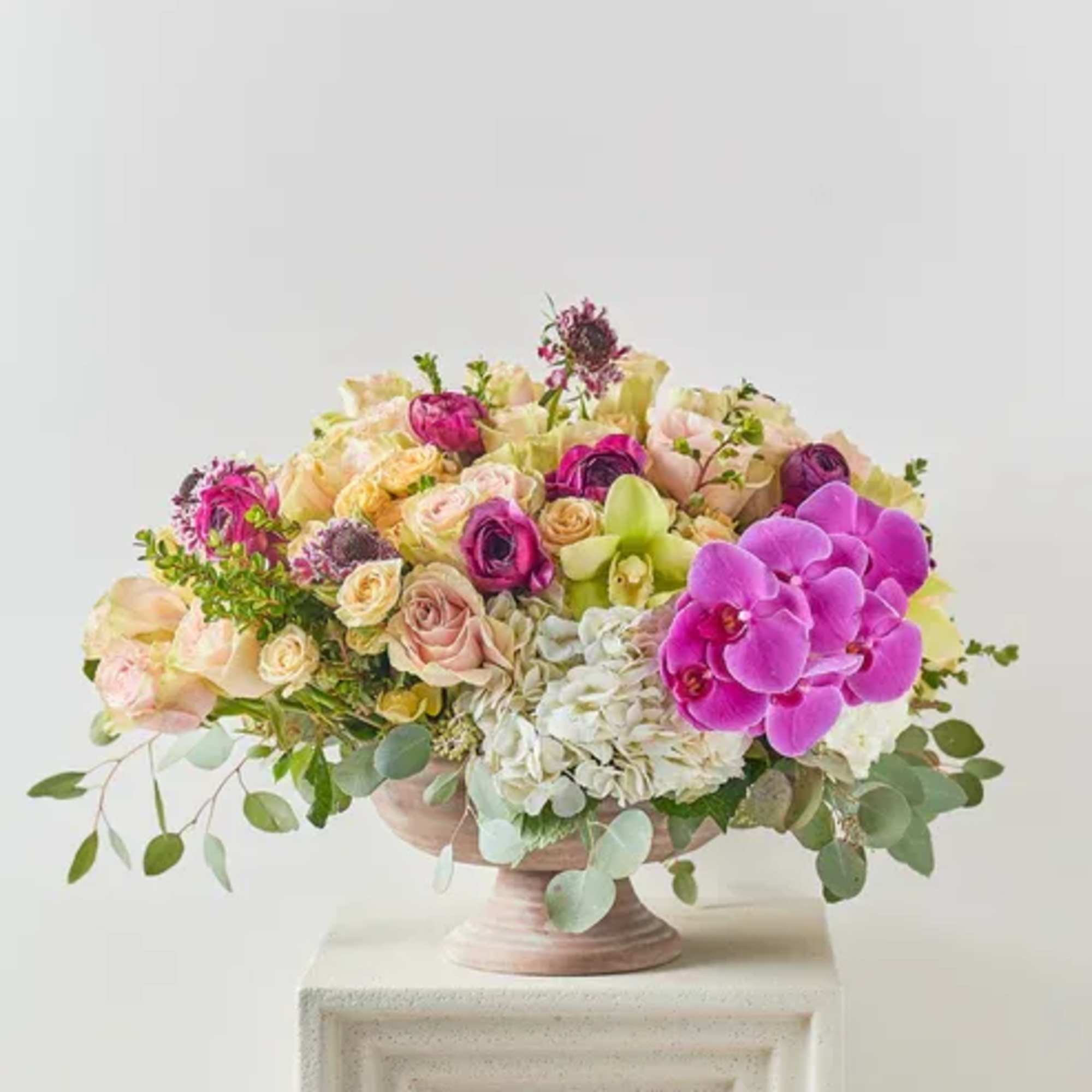 Mixed pink and cream floral arrangement in a pedestal bowl