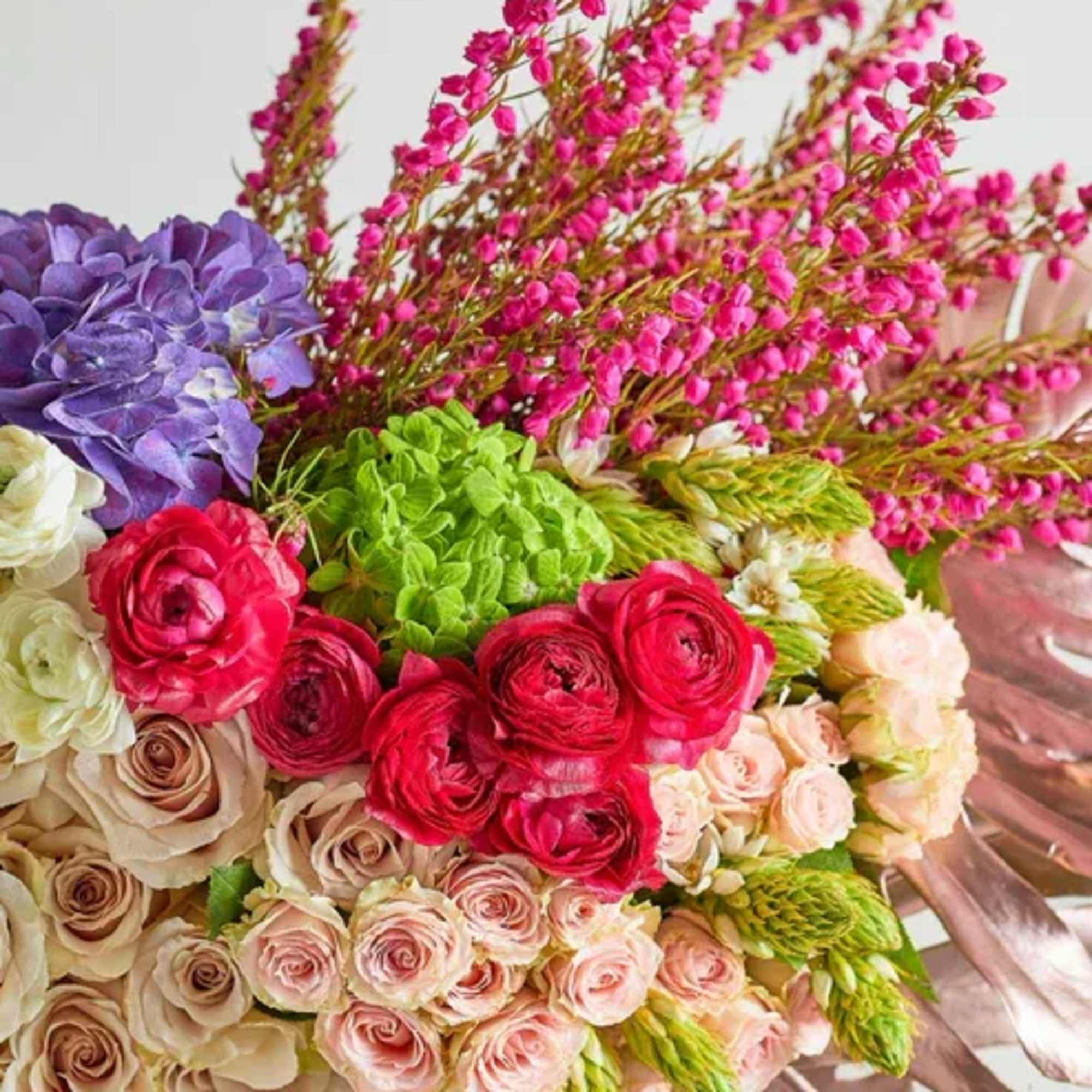 Bouquet of pink, purple, and cream flowers with a satin ribbon