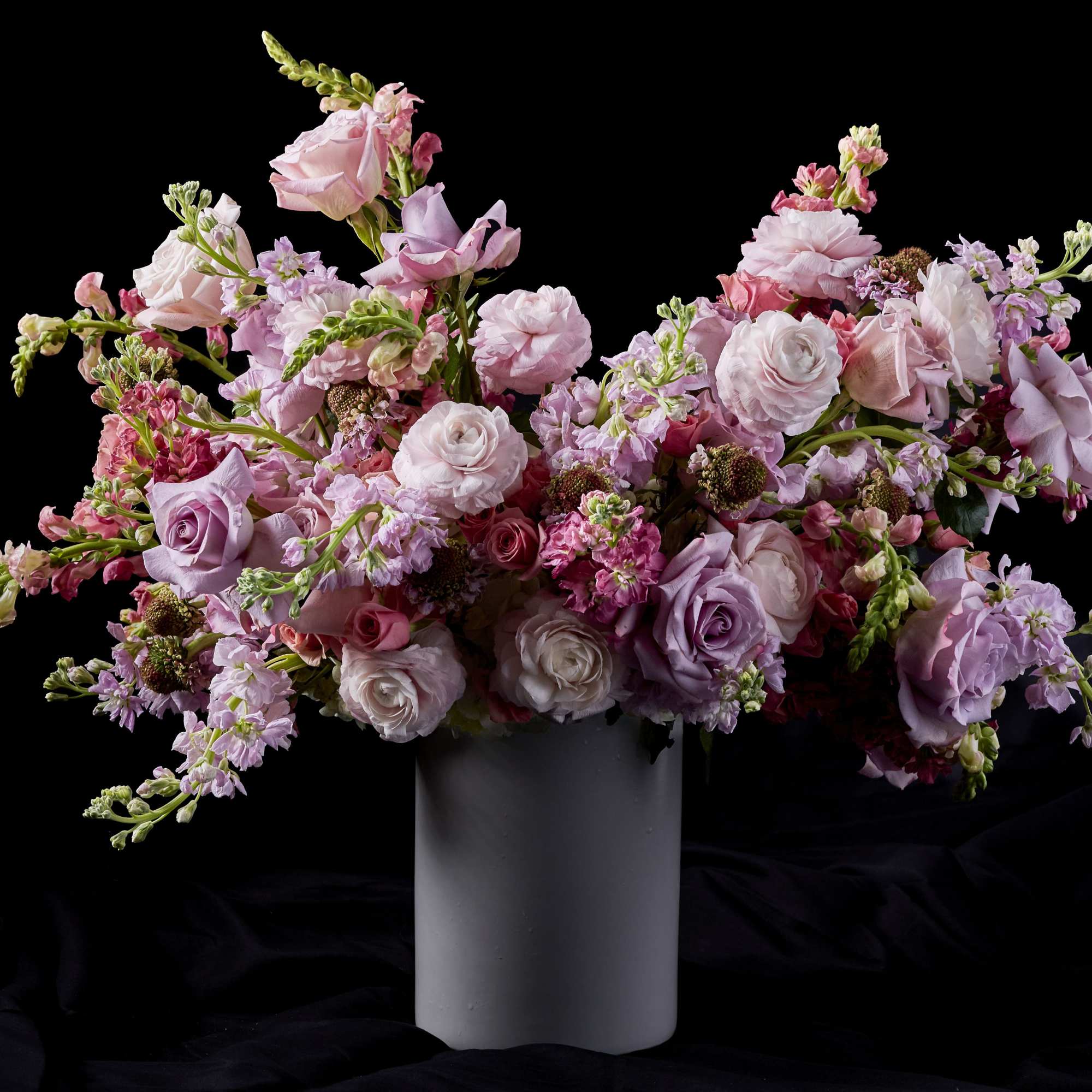Pink and lavender floral arrangement in a tall gray vase