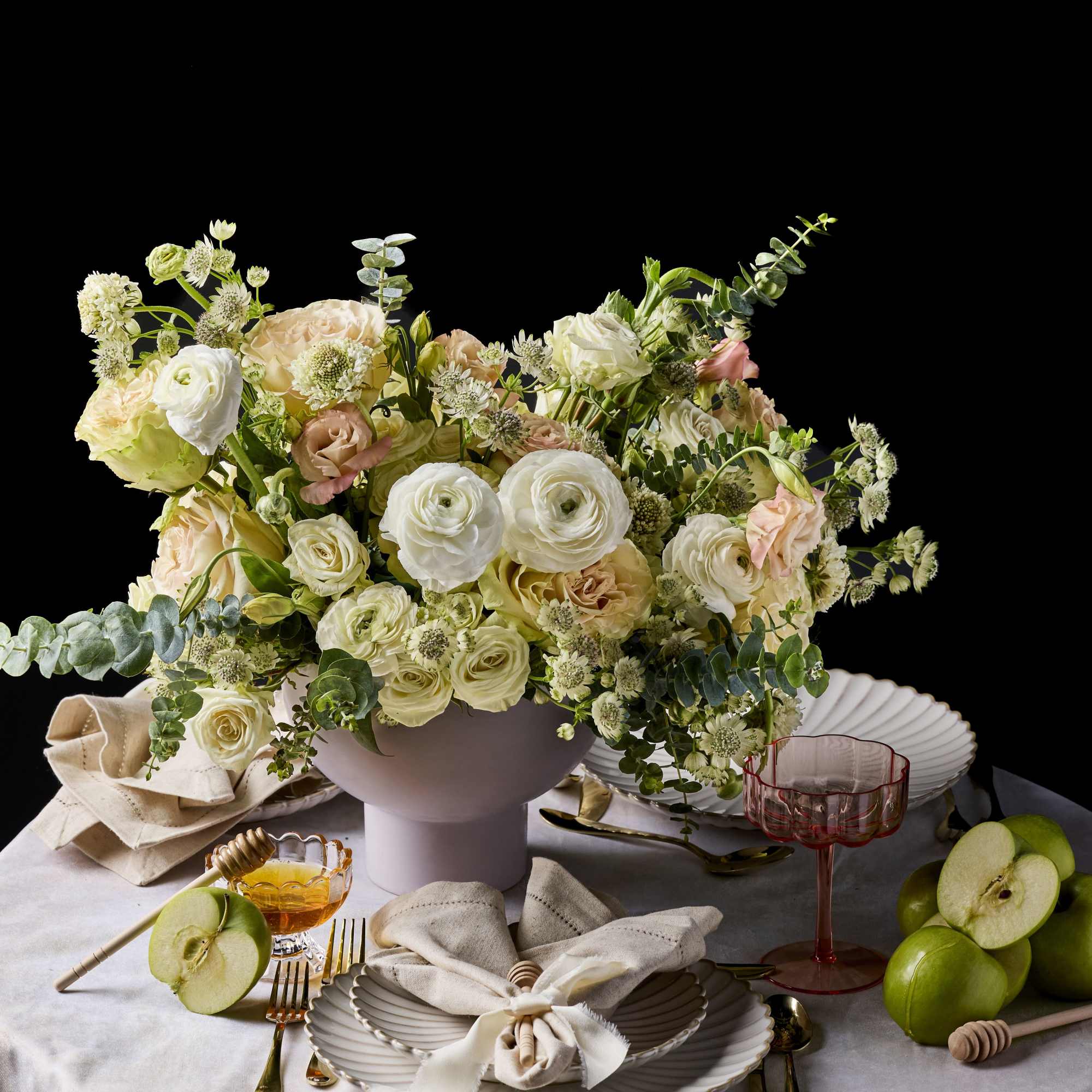 Pastel floral centerpiece in a pink vase on a set table