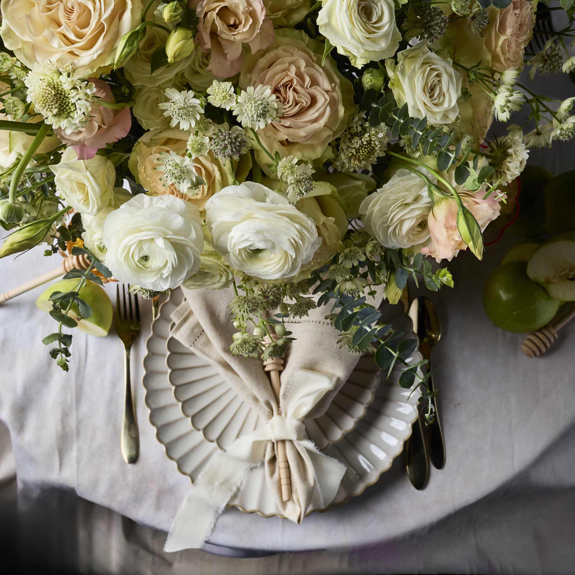 Bouquet of cream and blush roses with white ranunculus and greenery