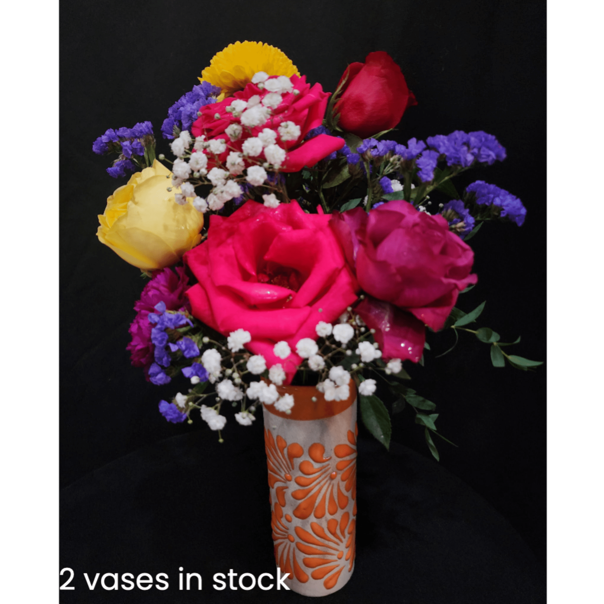 Bright mixed rose bouquet in a patterned vase