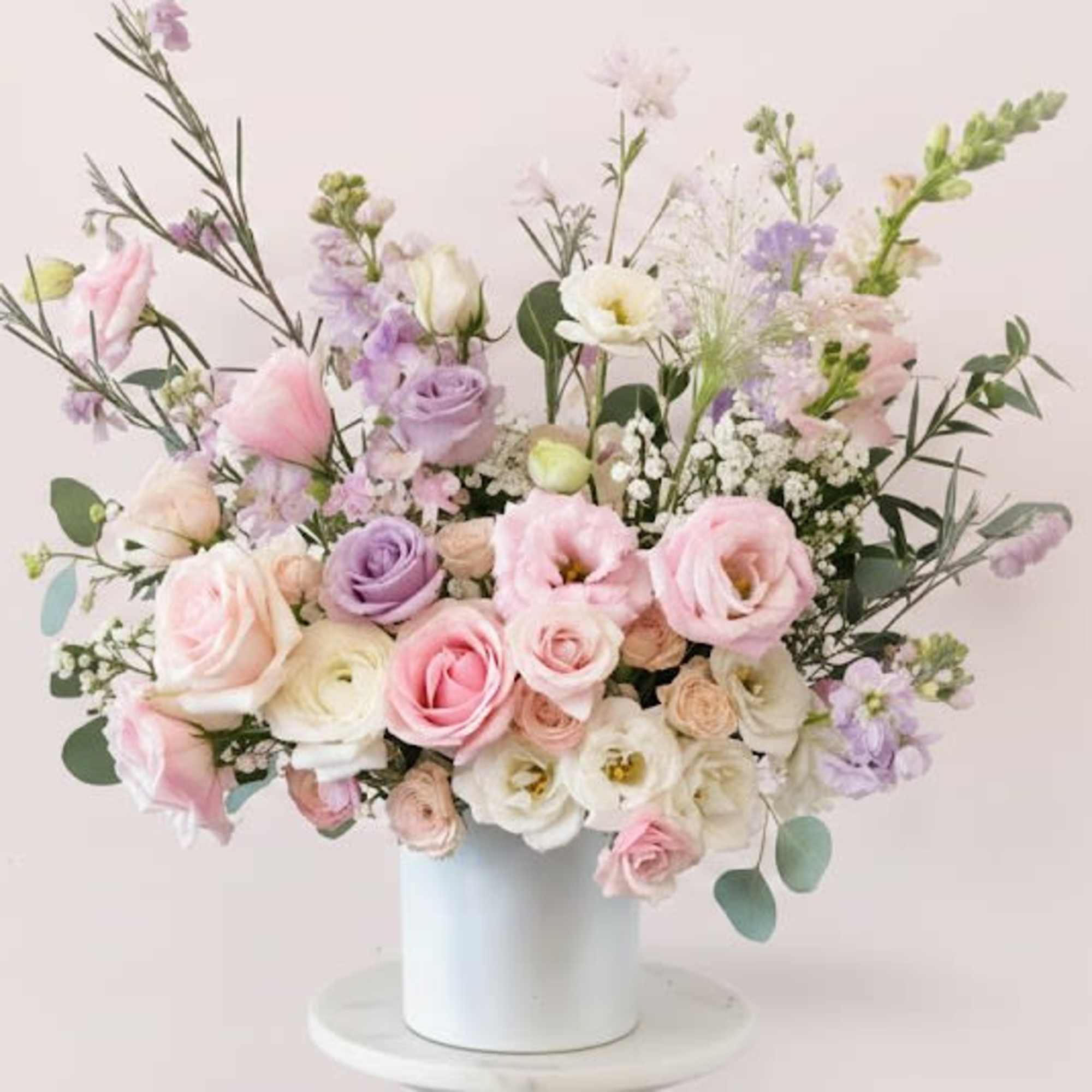 Pastel bouquet of roses and lisianthus in a white vase