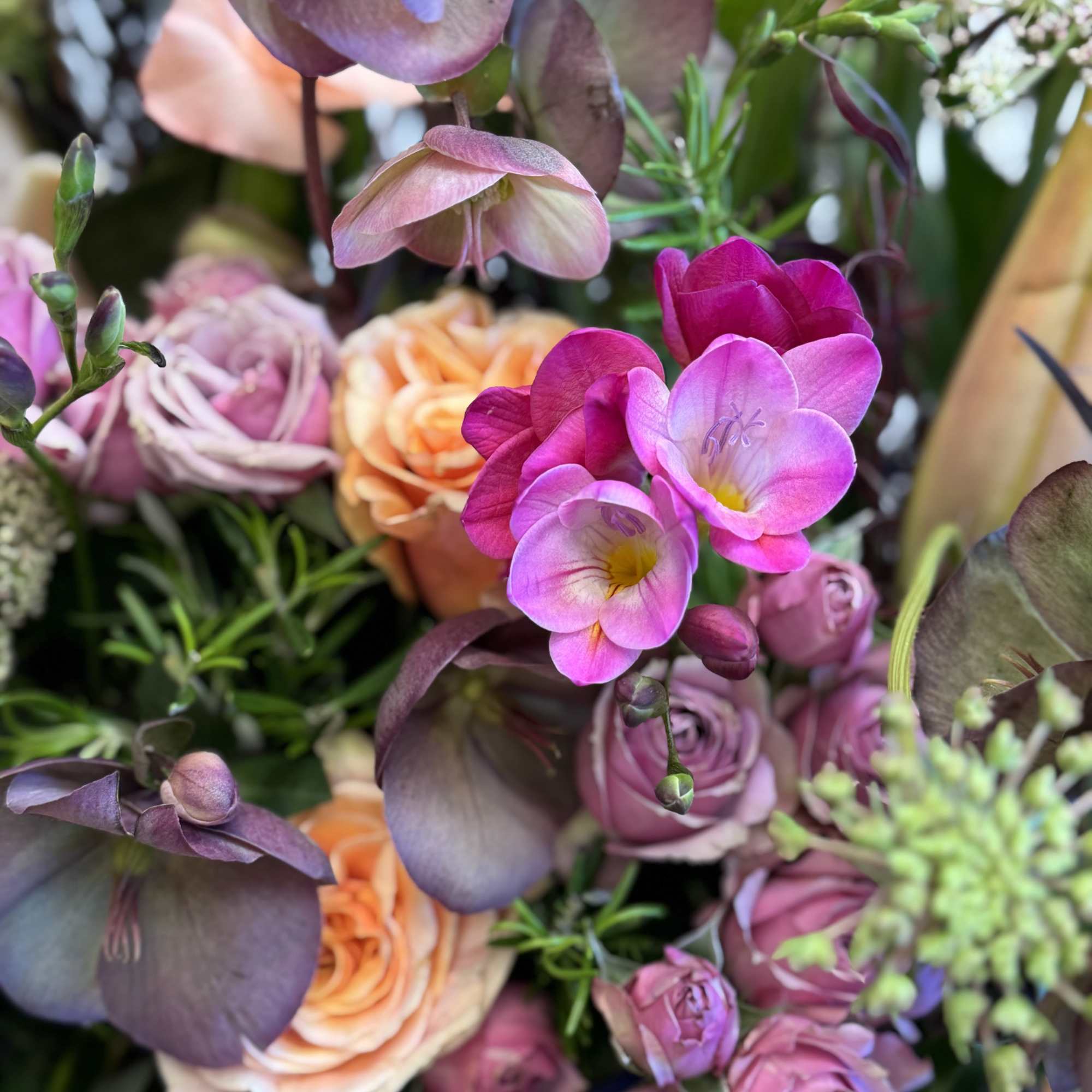 Bouquet of pink and peach roses with purple orchids