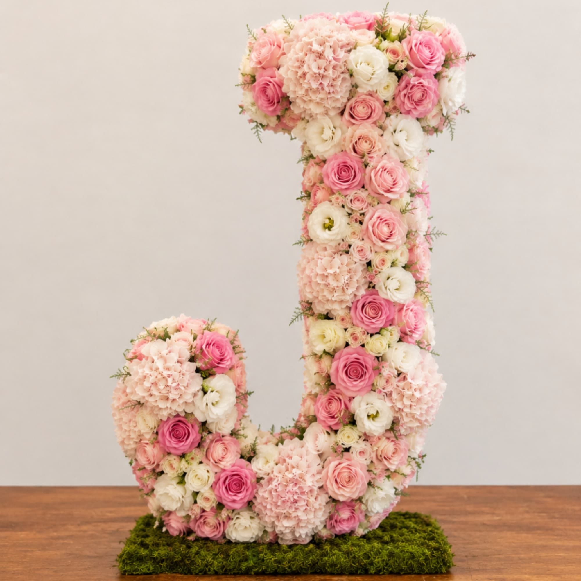 Floral arrangement shaped like a letter J in pink and white flowers
