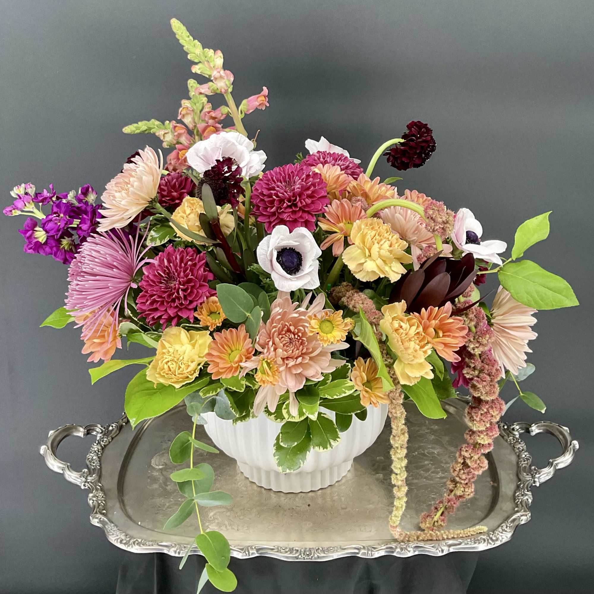 Mixed bouquet in a white vase with pink, peach, yellow, and white blooms