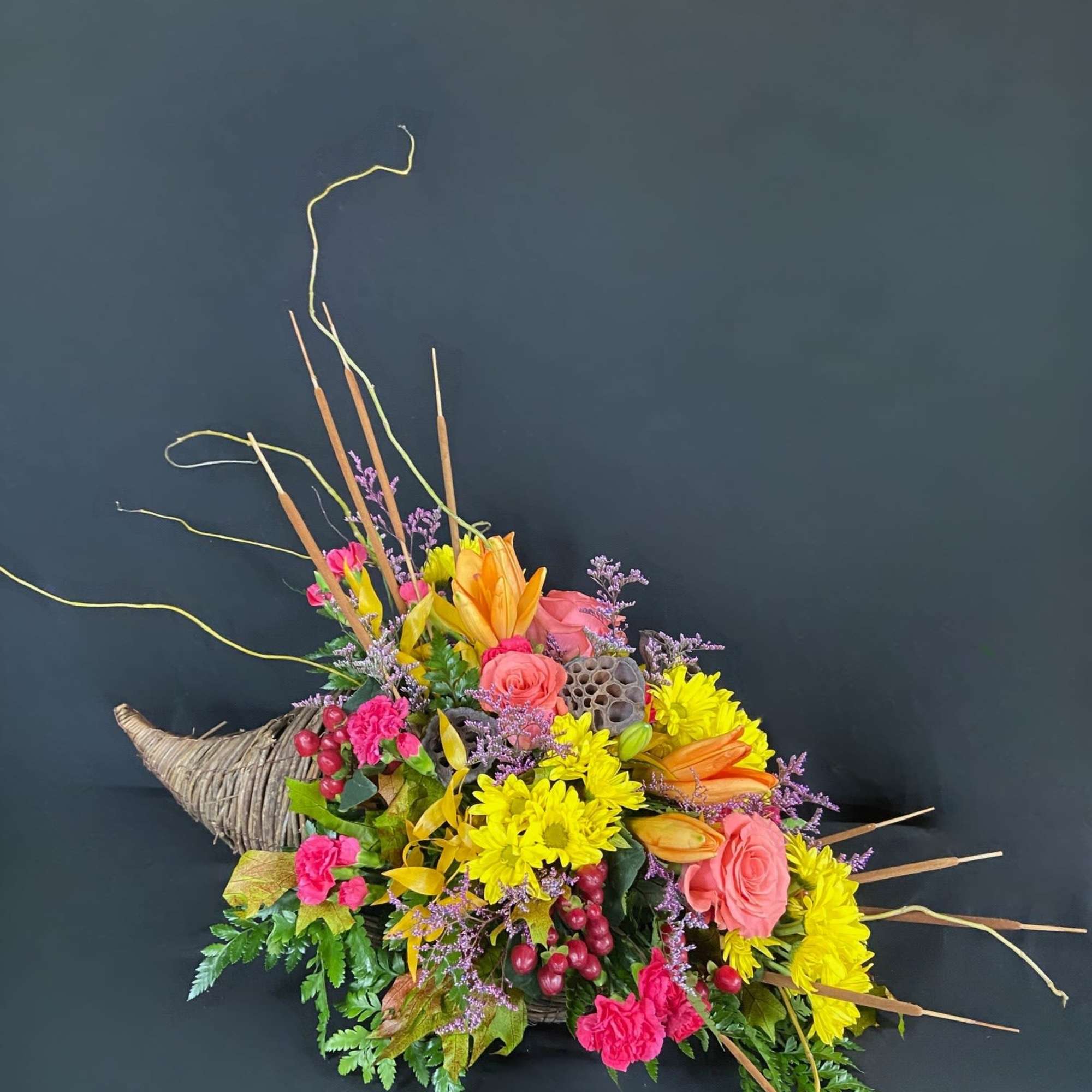 Colorful floral arrangement in a woven horn-shaped container