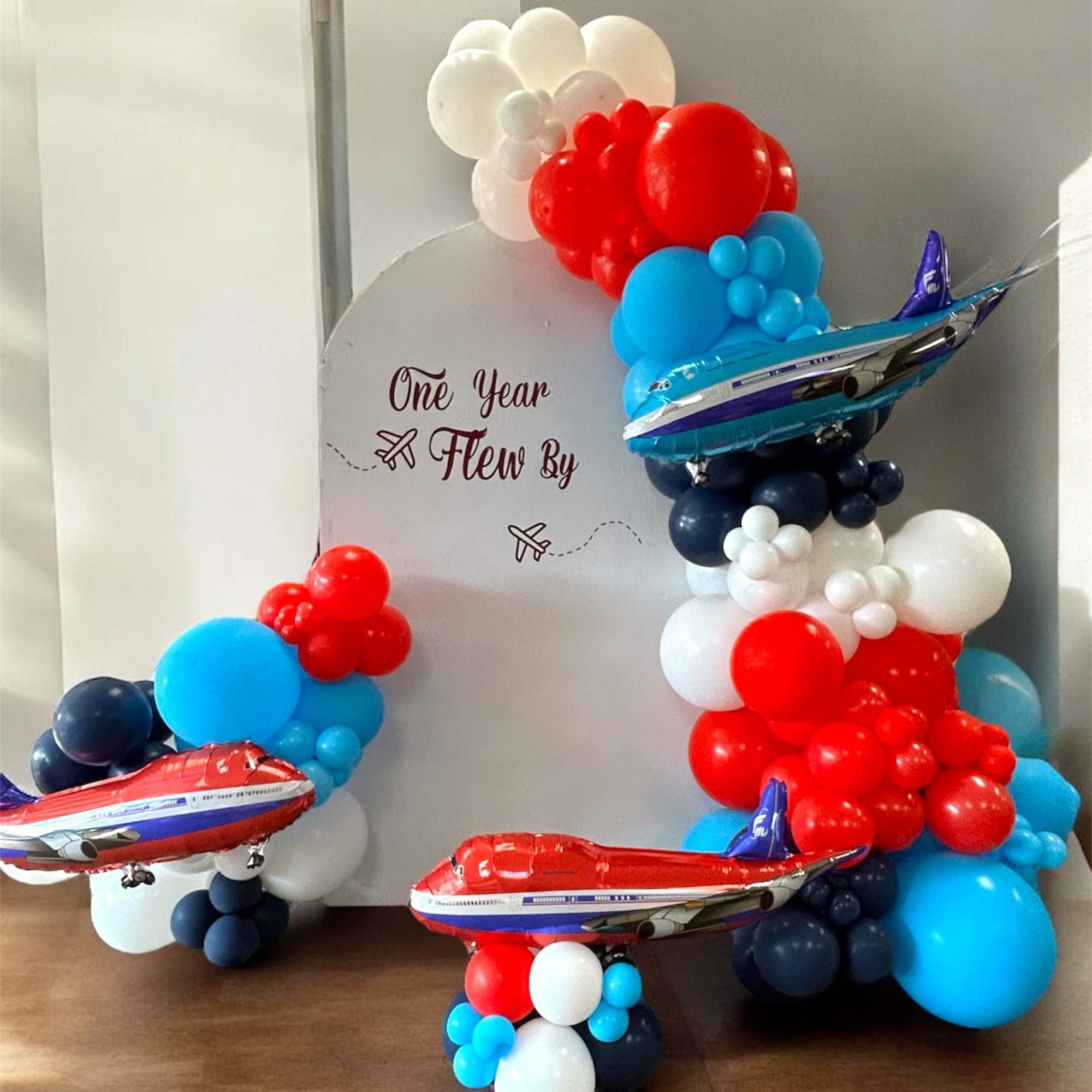 Airplane-themed balloon display with red, blue, and white balloons